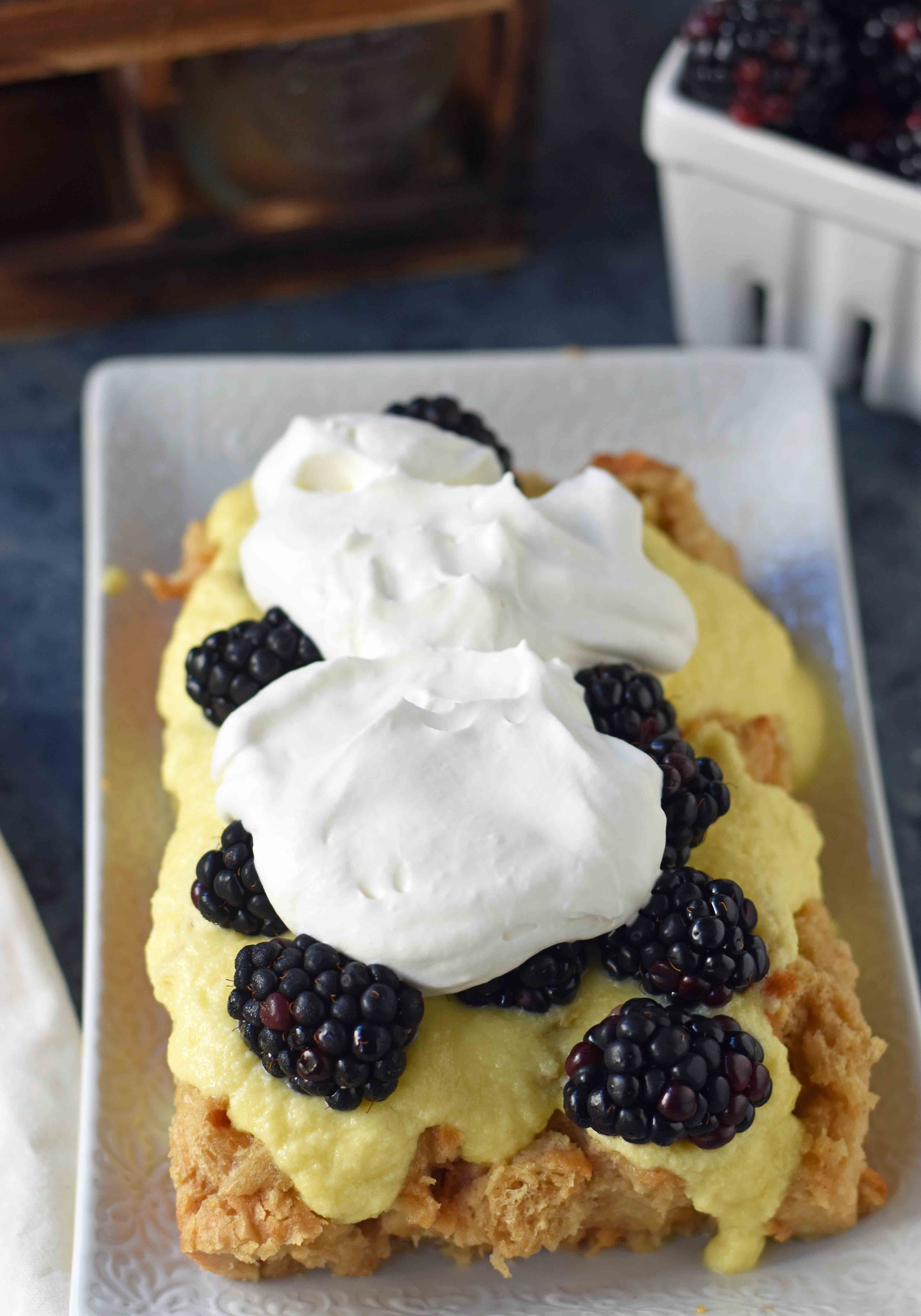 Blackberry Bread Pudding made with french bread soaked in vanilla custard, baked, and topped with creme anglaise sauce, freshly whipped cream, and fresh blackberries. A warm and comforting bread pudding dessert. www.modernhoney.com