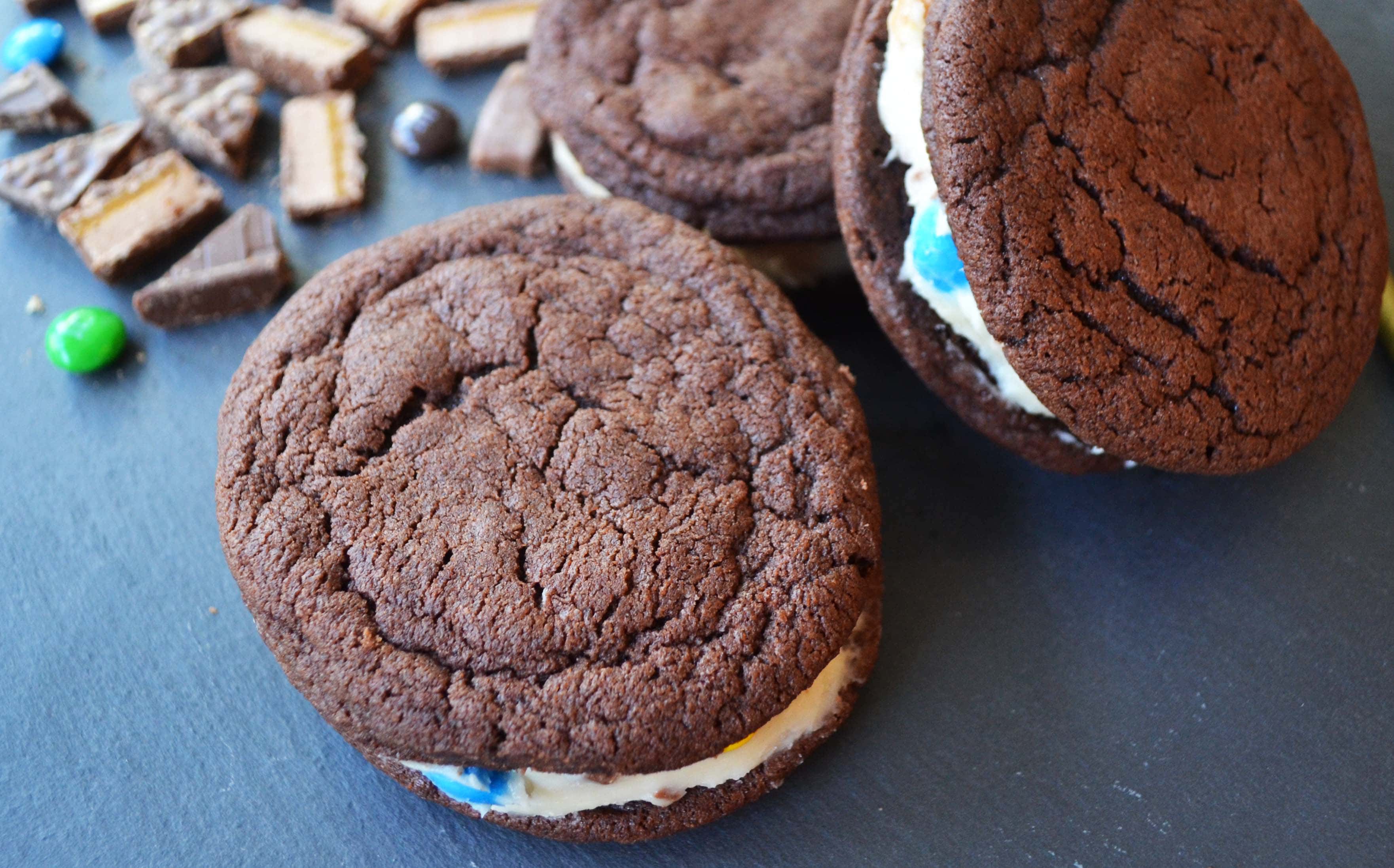 Oreo Stuffed Candy Monster Cookies. Homemade OREO cookies with a candy bar cream cheese filling. A soft chocolate cookie stuffed with a homemade filling made with cream cheese frosting and chocolate candy bars. A chocoholic's dream cookie! www.modernhoney.com