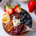 Acai Smoothie Bowl is made with a Brazilian berry mixed with frozen fruits and topped with fresh fruit and granola. How to make the popular acai smoothie bowls at home.