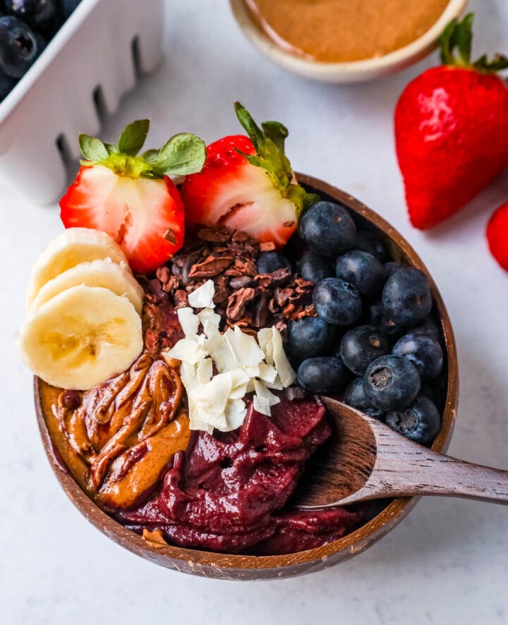 Homemade Acai Bowl is made with a Brazilian berry mixed with frozen fruits and topped with fresh fruit and granola. I will share tips on how to make the popular acai smoothie bowls at home for a fraction of the price. 