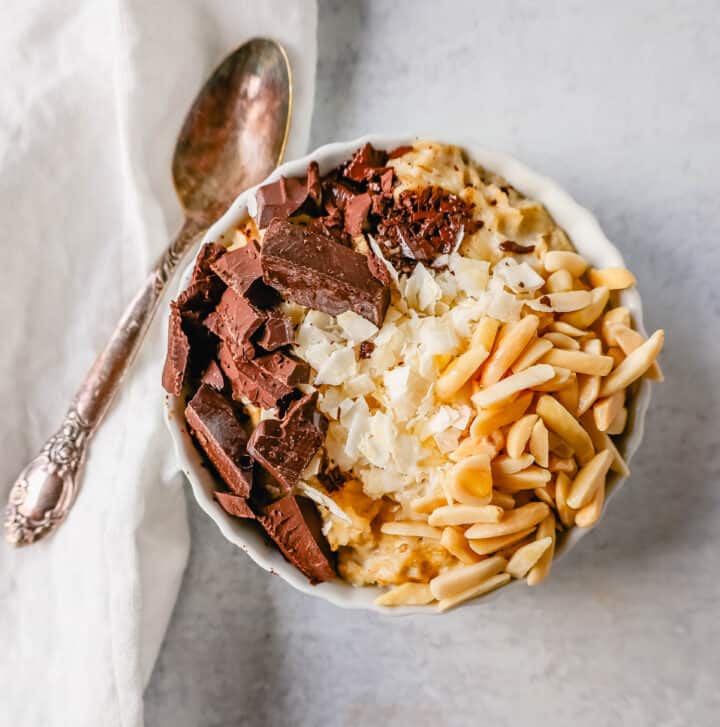 Almond Joy Oatmeal Coconut Chocolate and Almonds Oatmeal. How to make creamy oatmeal with your favorite toppings combinations. I am sharing a list of all of the popular oatmeal toppings ideas to serve on a cold winter day and how to make the best bowl of oatmeal!