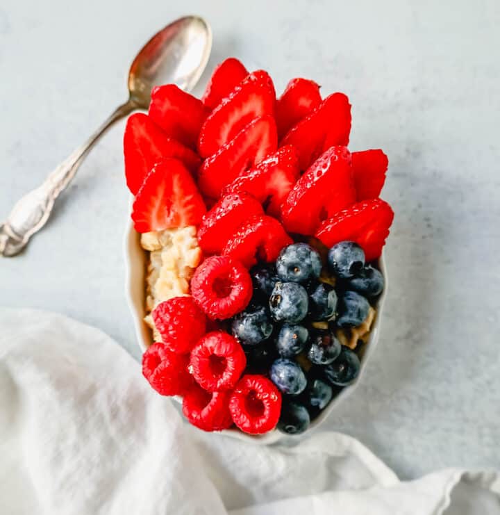 Blueberry Strawberry Oatmeal. How to make creamy oatmeal with your favorite toppings combinations. I am sharing a list of all of the popular oatmeal toppings ideas to serve on a cold winter day and how to make the best bowl of oatmeal!