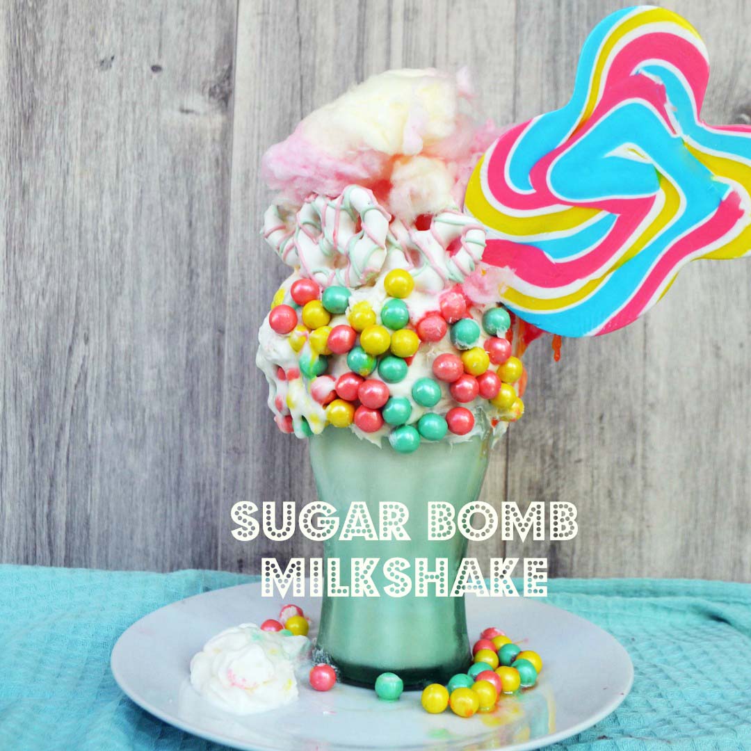 Black Tap Milkshake Copycat Recipe. The Sugar Bomb Milkshake by Modern Honey made with Vanilla Ice Cream, Sixlet Pastel Pearls, Cotton Candy, White Chocolate Covered Pretzels, Candy Sucker, and Whipped Cream. www.modernhoney.com