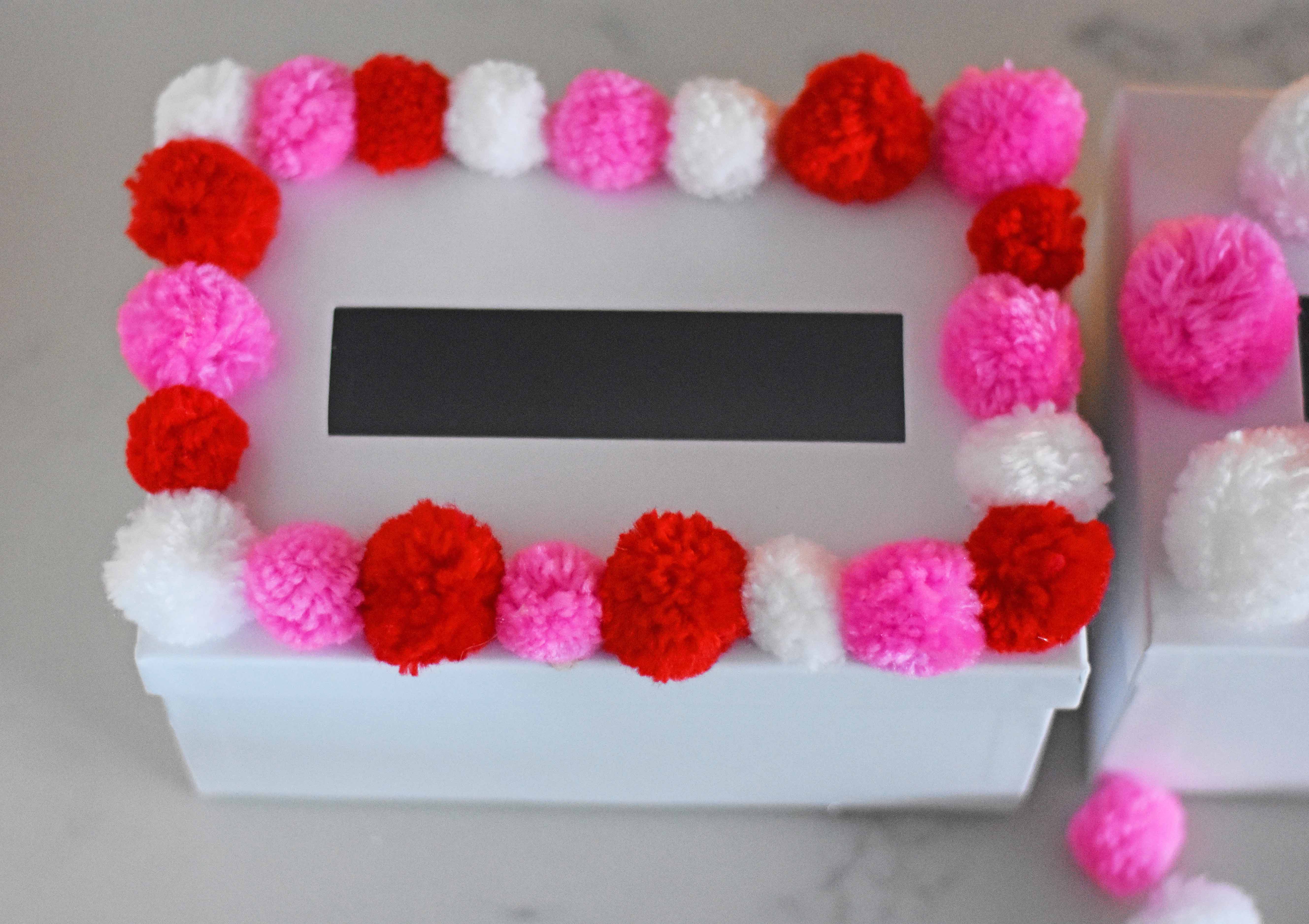 How to decorate Valentine's Day boxes with pom poms. Pom Poms Valentine's Day boxes.  Easy Valentine's Day boxes for school. Valentine's Day decorating ideas. www.modernhoney.com