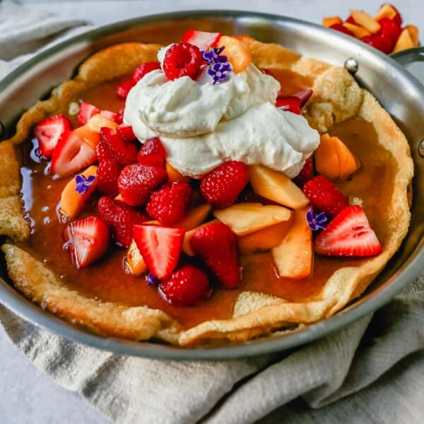 A decadent Dutch Baby Puff Pancake is made with milk, eggs, sugar, flour, and vanilla, and baked in a cast iron skillet in the oven until it puffs up and becomes a golden brown. This German pancake recipe is a delicious and easy breakfast dish!