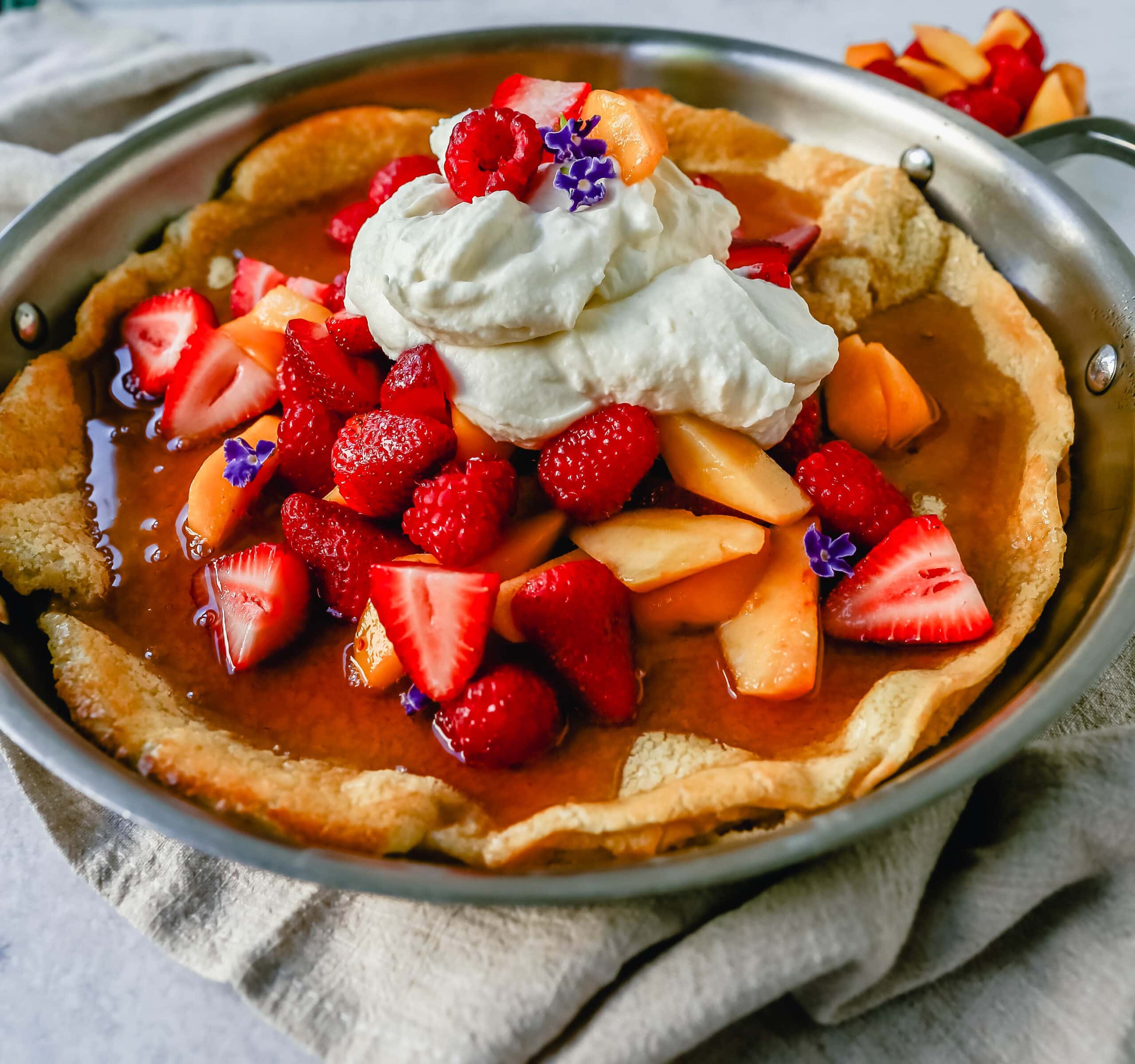 A decadent Dutch Baby Puff Pancake is made with milk, eggs, sugar, flour, and vanilla, and baked in a cast iron skillet in the oven until it puffs up and becomes a golden brown. A delicious and easy breakfast dish!