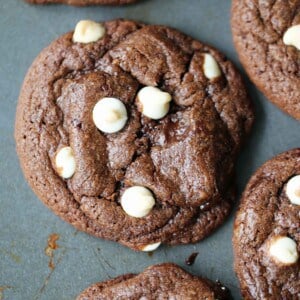 These triple chocolate cookies are made with rich cocoa powder, dark chocolate chunks, and white chocolate chunks for a fudgy, bakery-style cookie with crackly tops and thick, chewy centers. The secret is cold butter, which keeps these cookies thick instead of thin and spread out. The Best Black and White Chippers!