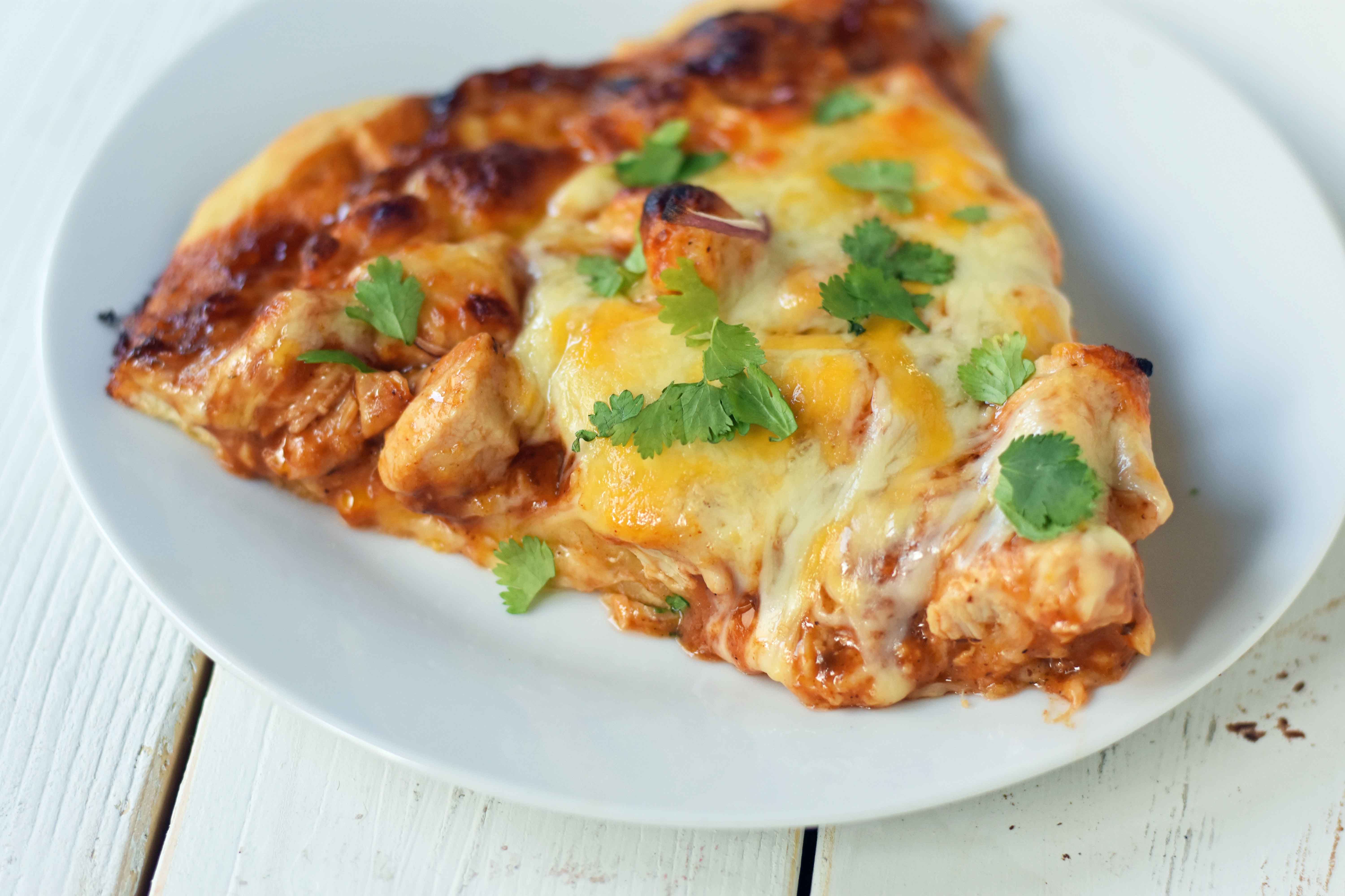 BBQ Chicken Pizza made with an easy homemade pizza crust, BBQ Ranch sauce, cheddar cheese, mozzarella cheese, chicken, red onion, and a touch of fresh cilantro. The BEST BBQ CHICKEN PIZZA. www.modernhoney.com