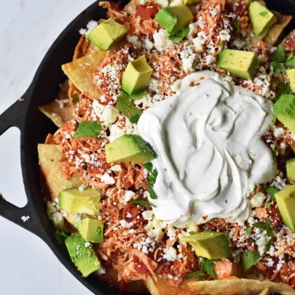 Easy Chicken Chilaquiles. How to make easy chicken chilaquiles with chipotle chicken, mexican cheese, and fresh avocado. A flavorful Mexican meal. www.modernhoney.com