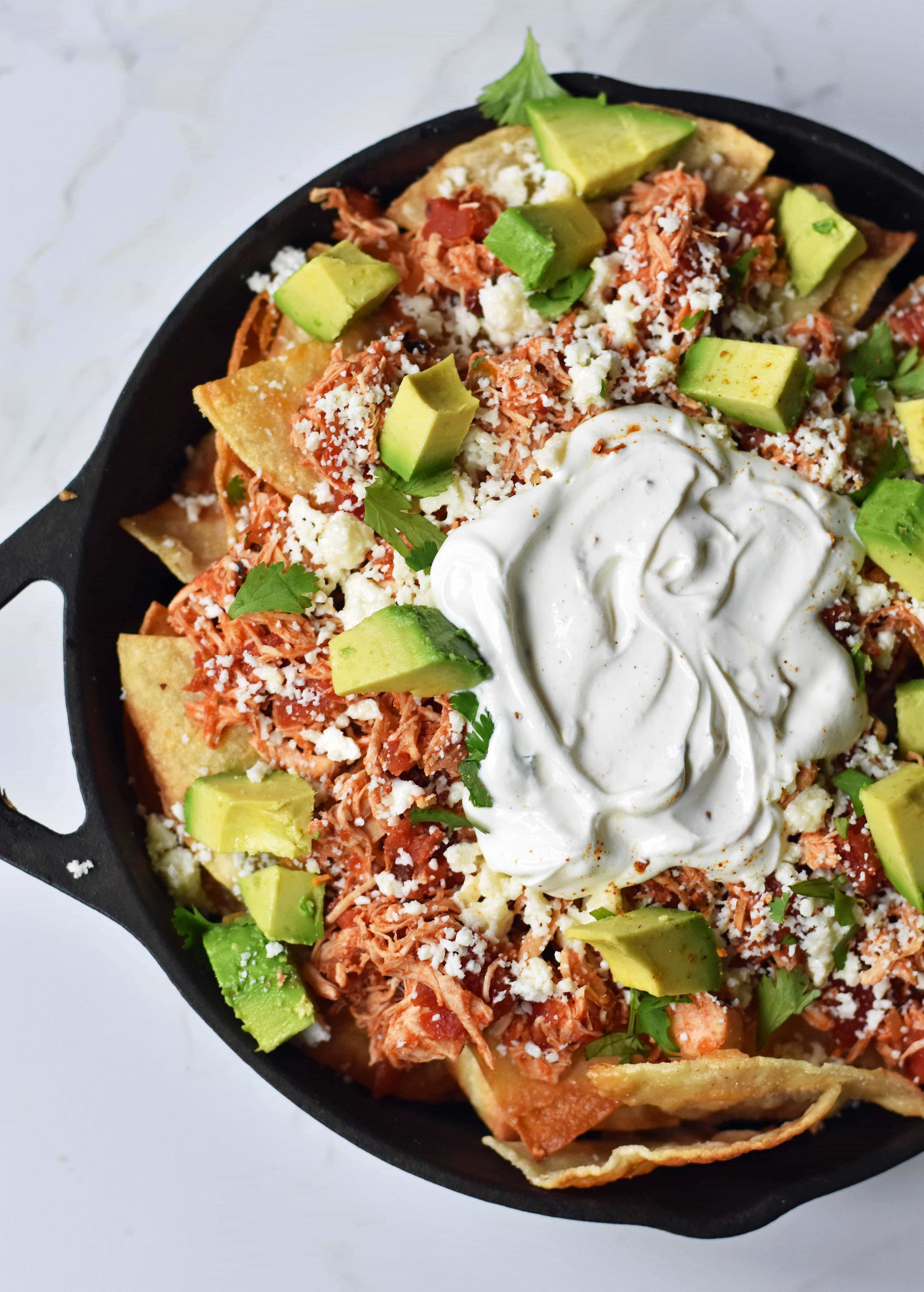 Easy Chicken Chilaquiles. How to make easy chicken chilaquiles with chipotle chicken, mexican cheese, and fresh avocado. A flavorful Mexican meal. www.modernhoney.com