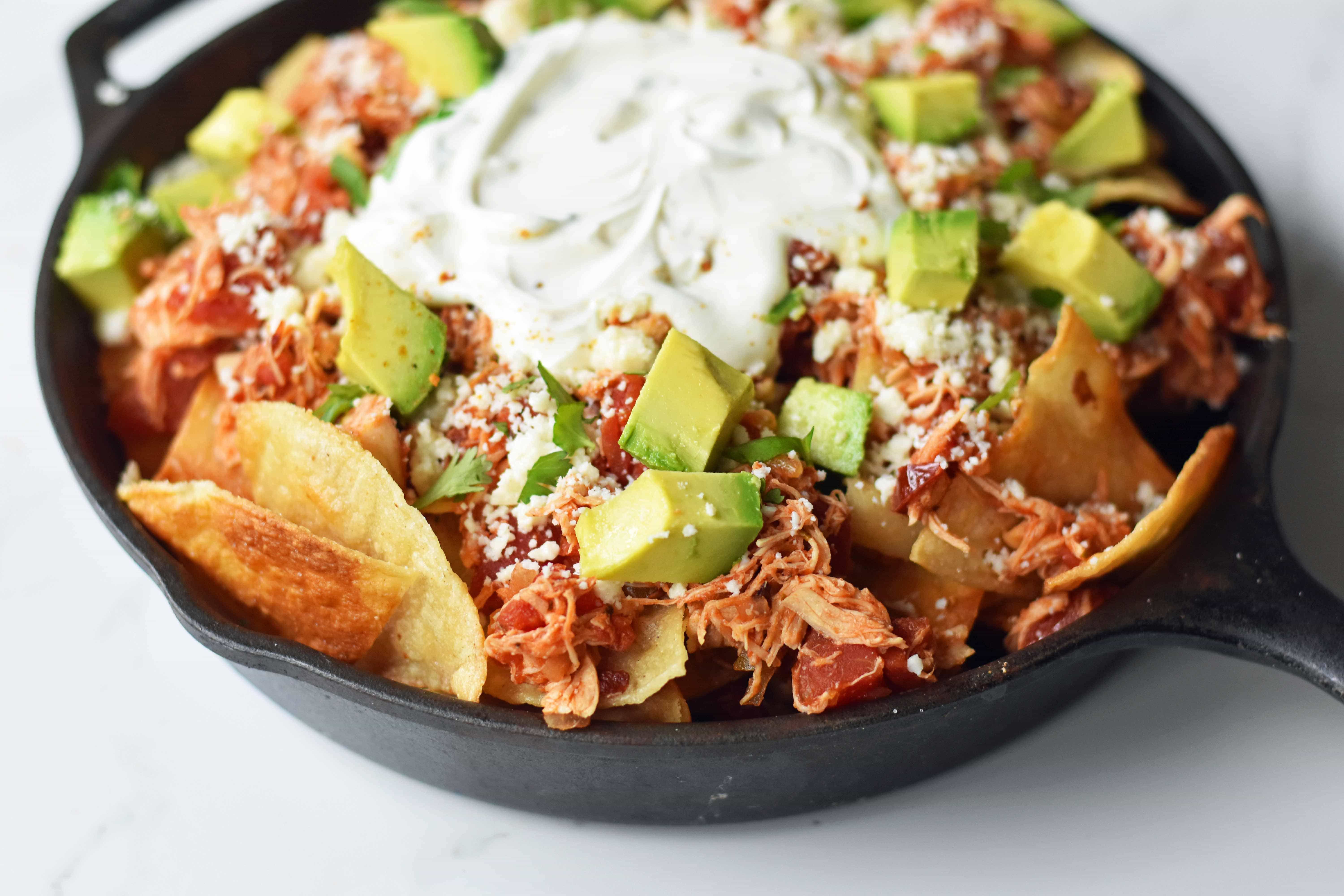 Easy Chicken Chilaquiles. How to make easy chicken chilaquiles with chipotle chicken, mexican cheese, and fresh avocado. A flavorful Mexican meal. www.modernhoney.com