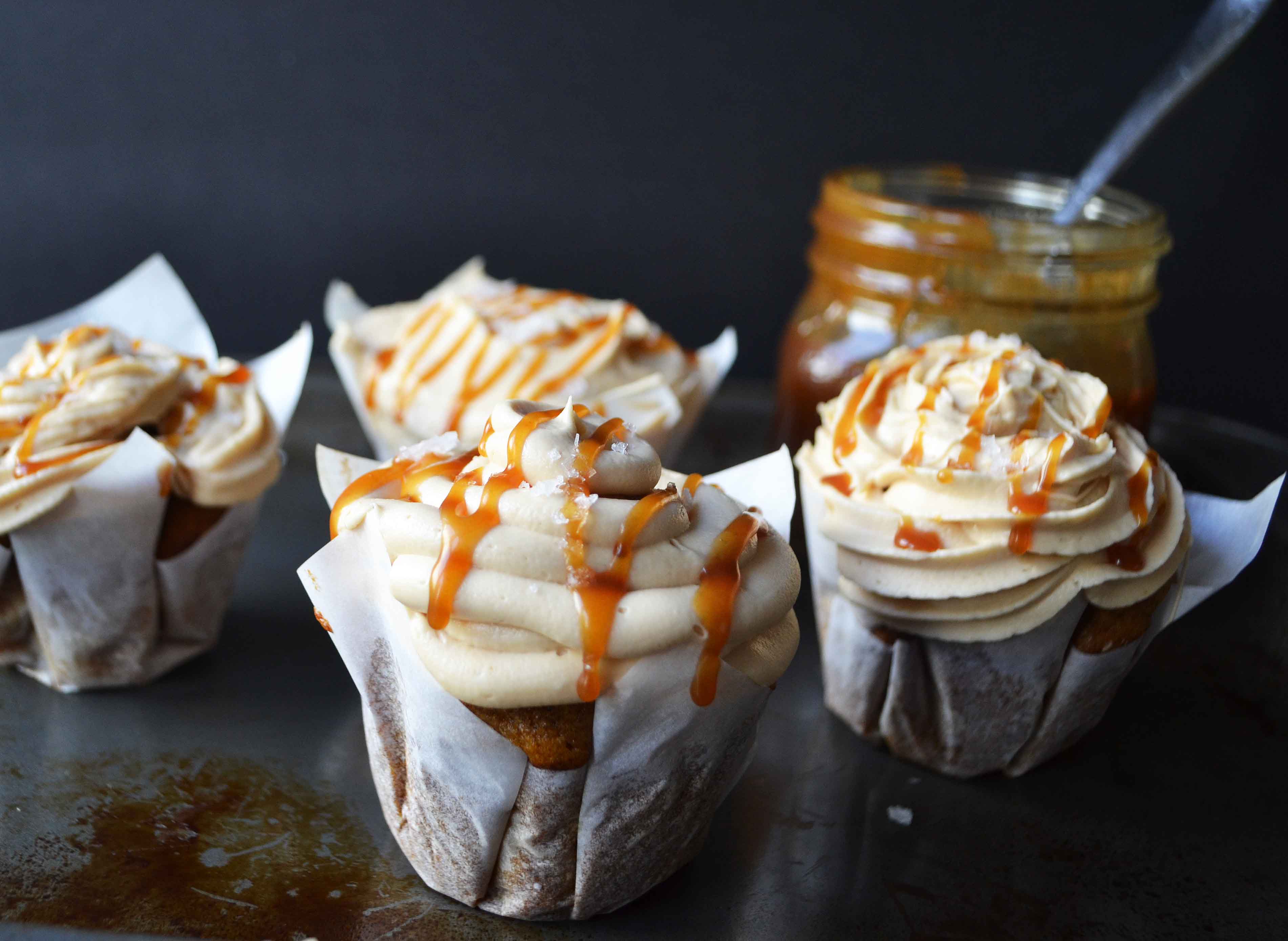 Pumpkin Cupcakes with Salted Caramel Frosting by Modern Honey. Homemade, made from scratch salted carmel frosting tops a cinnamon spiced pumpkin cupcake. The perfect Fall dessert! www.modernhoney.com