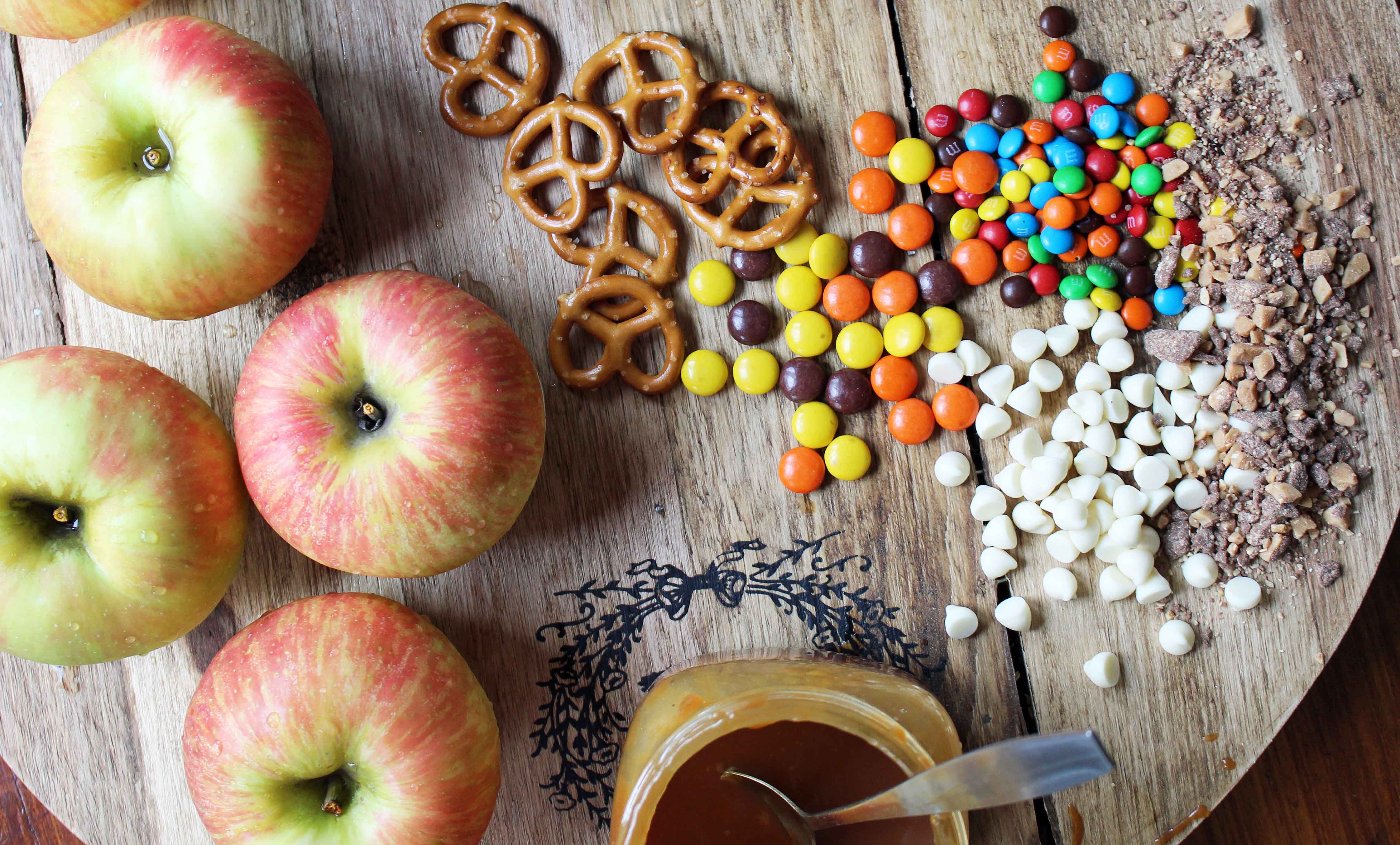 Candy Madness Caramel Apple Nachos by Modern Honey. Crisp Apples topped with Salted Caramel, White Chocolate, M &M's, Reeses Pieces, Heath Toffee Bits, Snickers, and Chocolate Covered Pretzels. These Caramel Apple Nachos are much easier than making caramel apples and will be a huge hit at your next party!