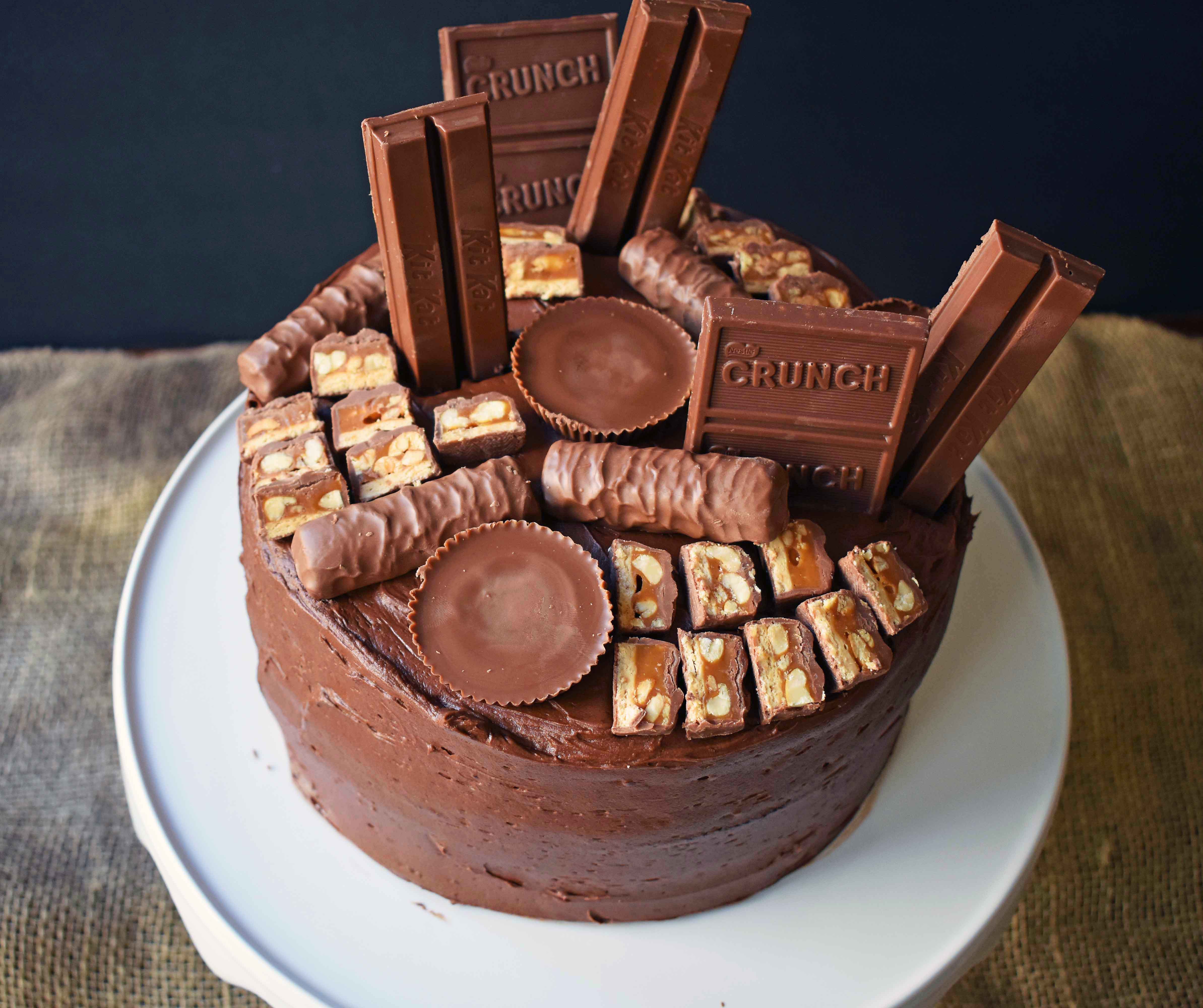 Candy Bar Stash Chocolate Cake by Modern Honey. Perfect chocolate cake topped with chocolate buttercream and the most popular candy bars. It's the ultimate Chocolate Candy Bar Cake.