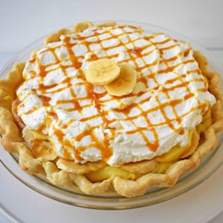 Salted Caramel Banana Cream Pie. Sweet Homemade Custard topped with fresh bananas, handcrafted salted caramel, and sweetened whipped cream all on a flaky, buttery crust.