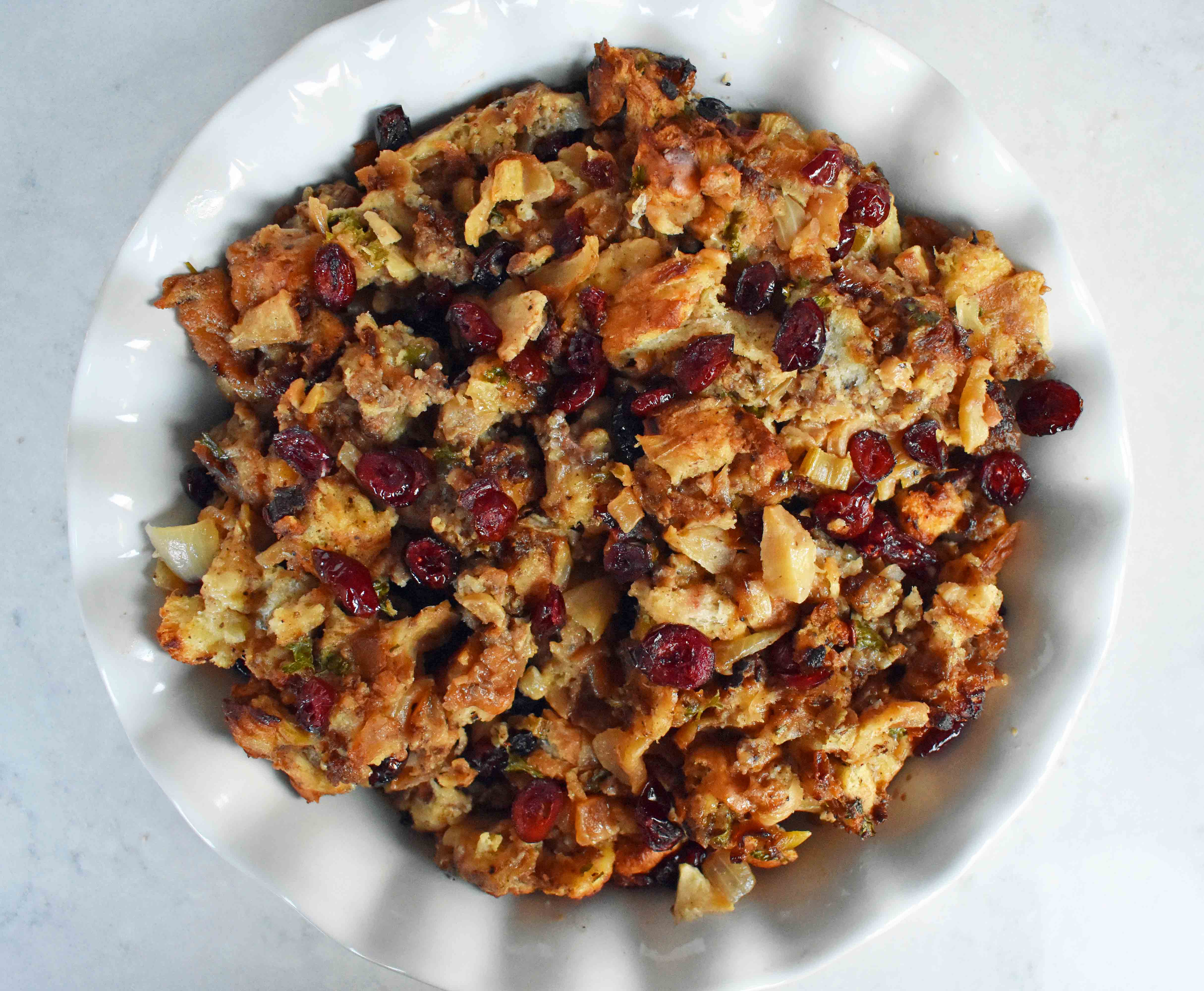 Cranberry Apple Sausage Stuffing by Modern Honey. Classic Bread Stuffing with Sausage, Dried Cranberries, and Crisp Apples. The perfect Thanksgiving side dish recipe!