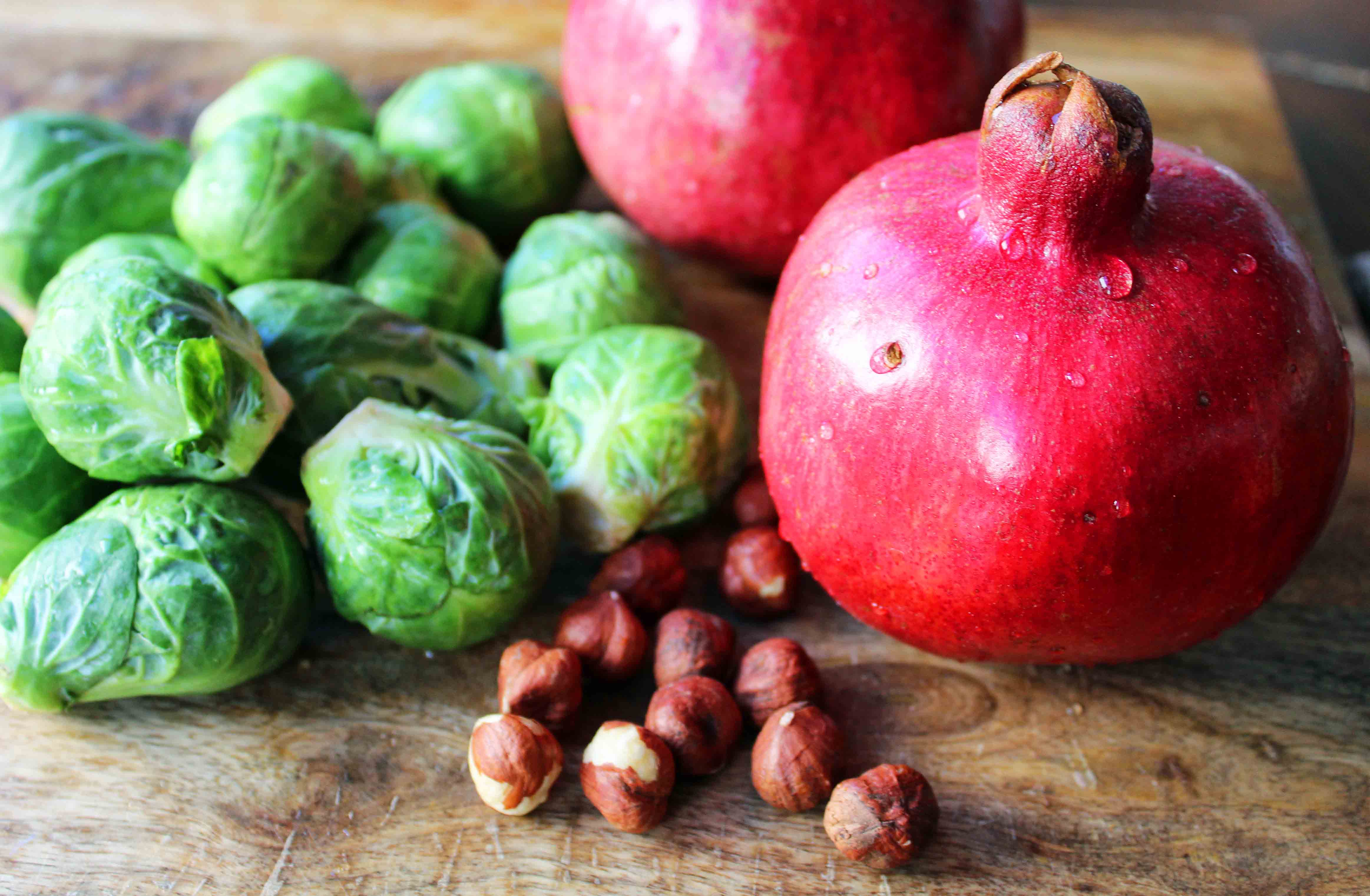 Bacon Roasted Brussels Sprouts with Pomegranates by Modern Honey. Roasted Brussels Sprouts in Extra Virgin Olive Oil, Crispy Bacon, Pomegranates, and Hazelnuts. The perfect healthy Thanksgiving side dish.