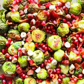 Bacon Roasted Brussell Sprouts with Pomegranates by Modern Honey. Roasted Brussell Sprouts in Extra Virgin Olive Oil, Crispy Bacon, Pomegranates, and Hazelnuts. The perfect healthy Thanksgiving side dish.