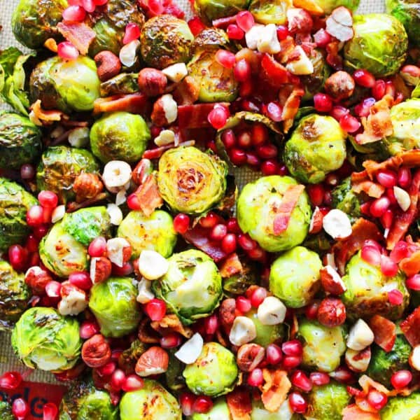 Bacon Roasted Brussels Sprouts with Pomegranates by Modern Honey. Roasted Brussels Sprouts in Extra Virgin Olive Oil, Crispy Bacon, Pomegranates, and Hazelnuts. The perfect healthy Thanksgiving side dish.