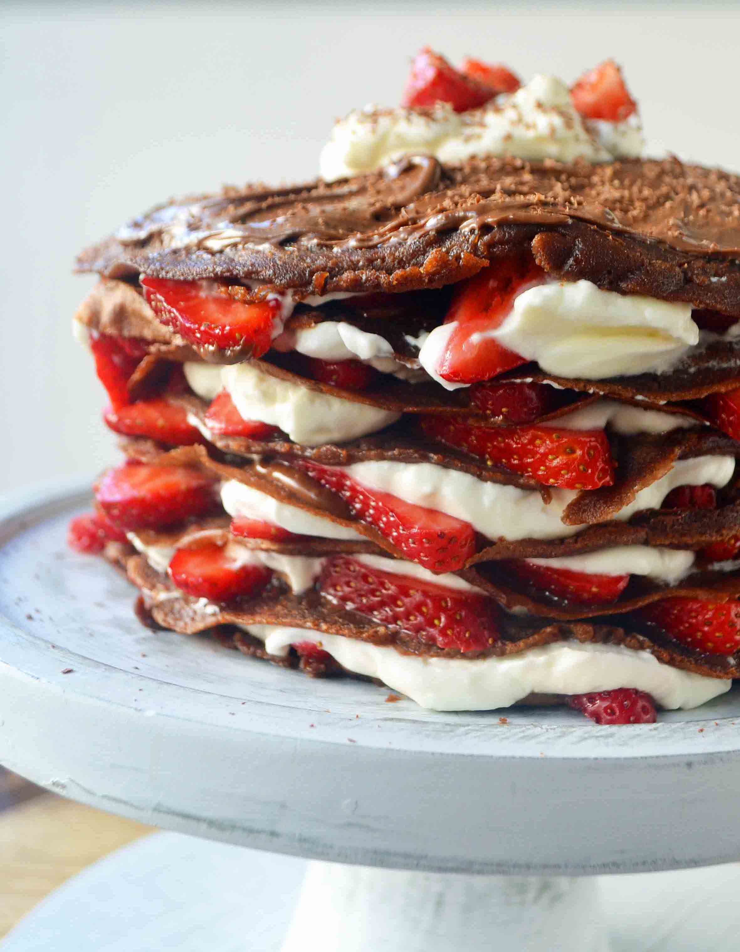 Strawberry Nutella Chocolate Crepe Cake. Layers of chocolate crepes, whipping cream, nutella, and fresh strawberries. www.modernhoney.com