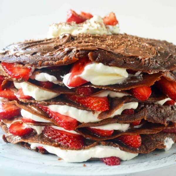 Strawberry Nutella Chocolate Crepe Cake. Layers of chocolate crepes, whipping cream, nutella, and fresh strawberries.
