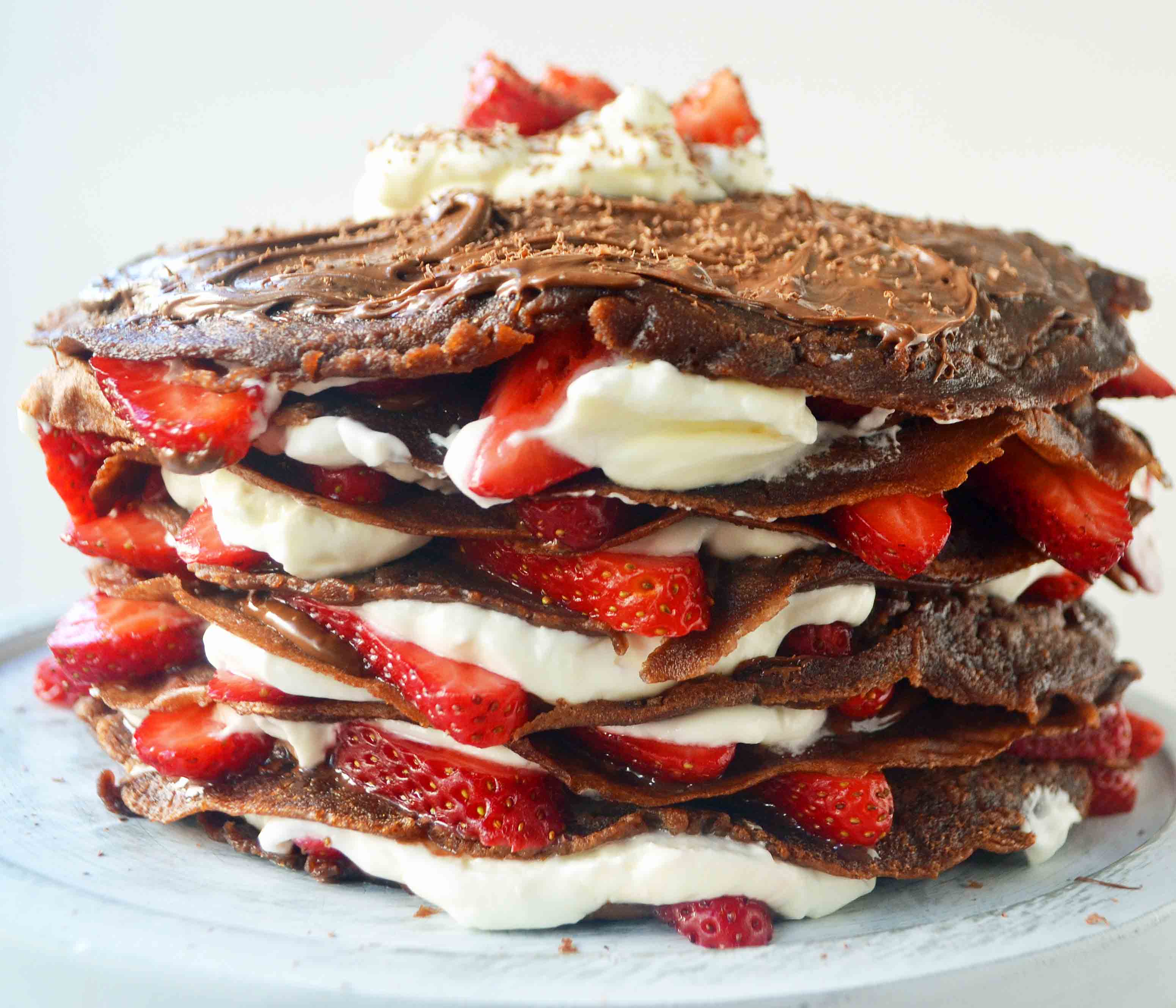 Strawberry Nutella Chocolate Crepe Cake. Layers of chocolate crepes, whipping cream, nutella, and fresh strawberries.