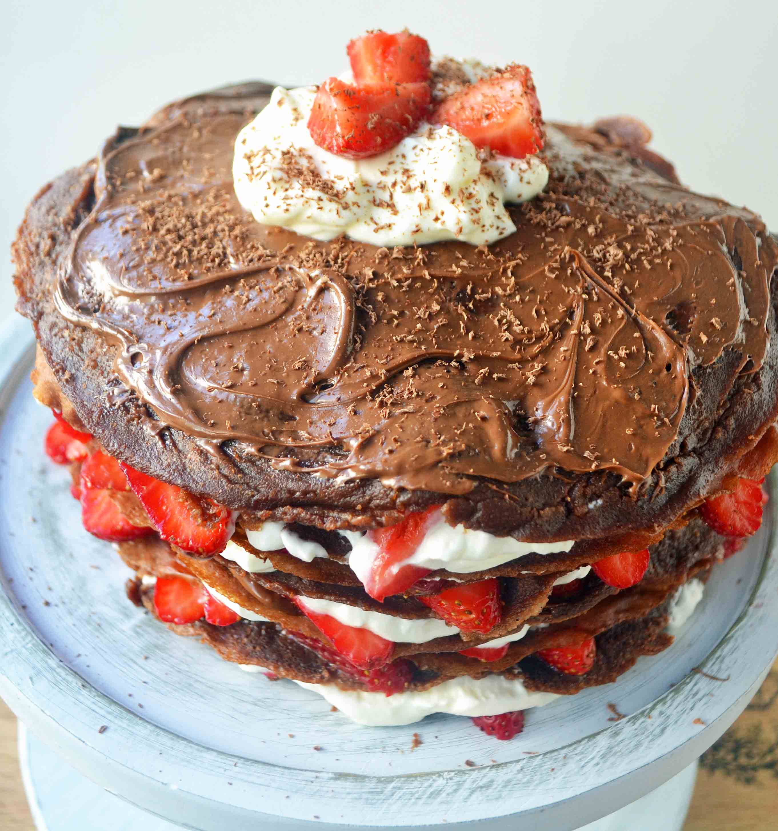 Strawberry Nutella Chocolate Crepe Cake. Layers of chocolate crepes, whipping cream, nutella, and fresh strawberries.