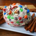 Chocolate Candy Bar Cheese Ball by Modern Honey. A popular sweet cheese ball that is perfect for parties. Dip pretzels in sweet candy bar dip.