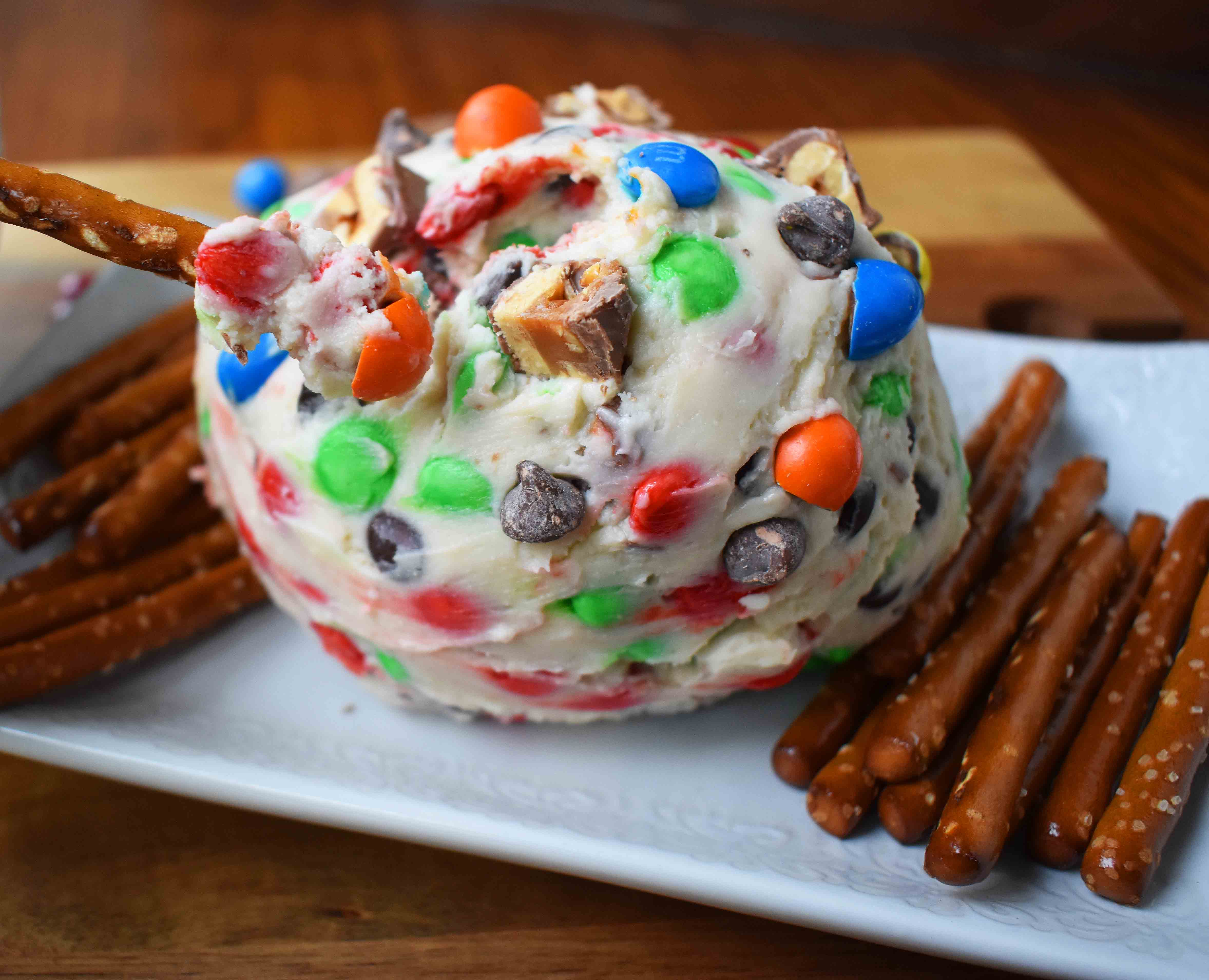 Chocolate Candy Bar Cheese Ball by Modern Honey. A popular sweet cheese ball that is perfect for parties. Dip pretzels in sweet candy bar dip. 