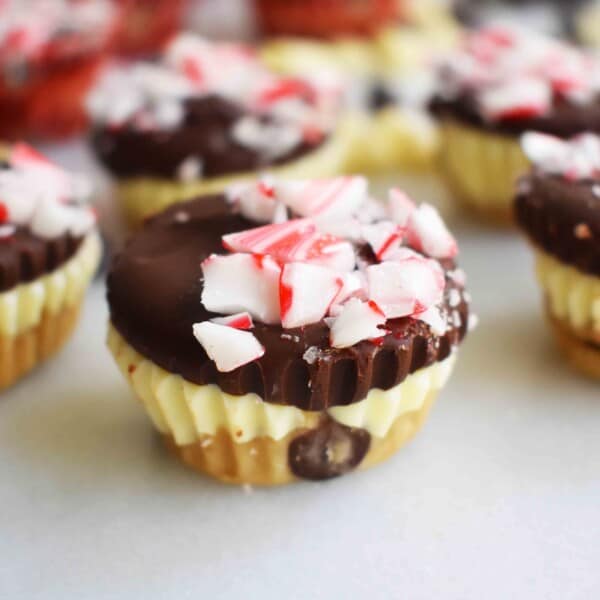 Peppermint Bark Cookie Dough Cups by Modern Honey. Egg Free Chocolate Chip Cookie Dough layered with white chocolate and semisweet chocolate and topped with crushed candy canes.