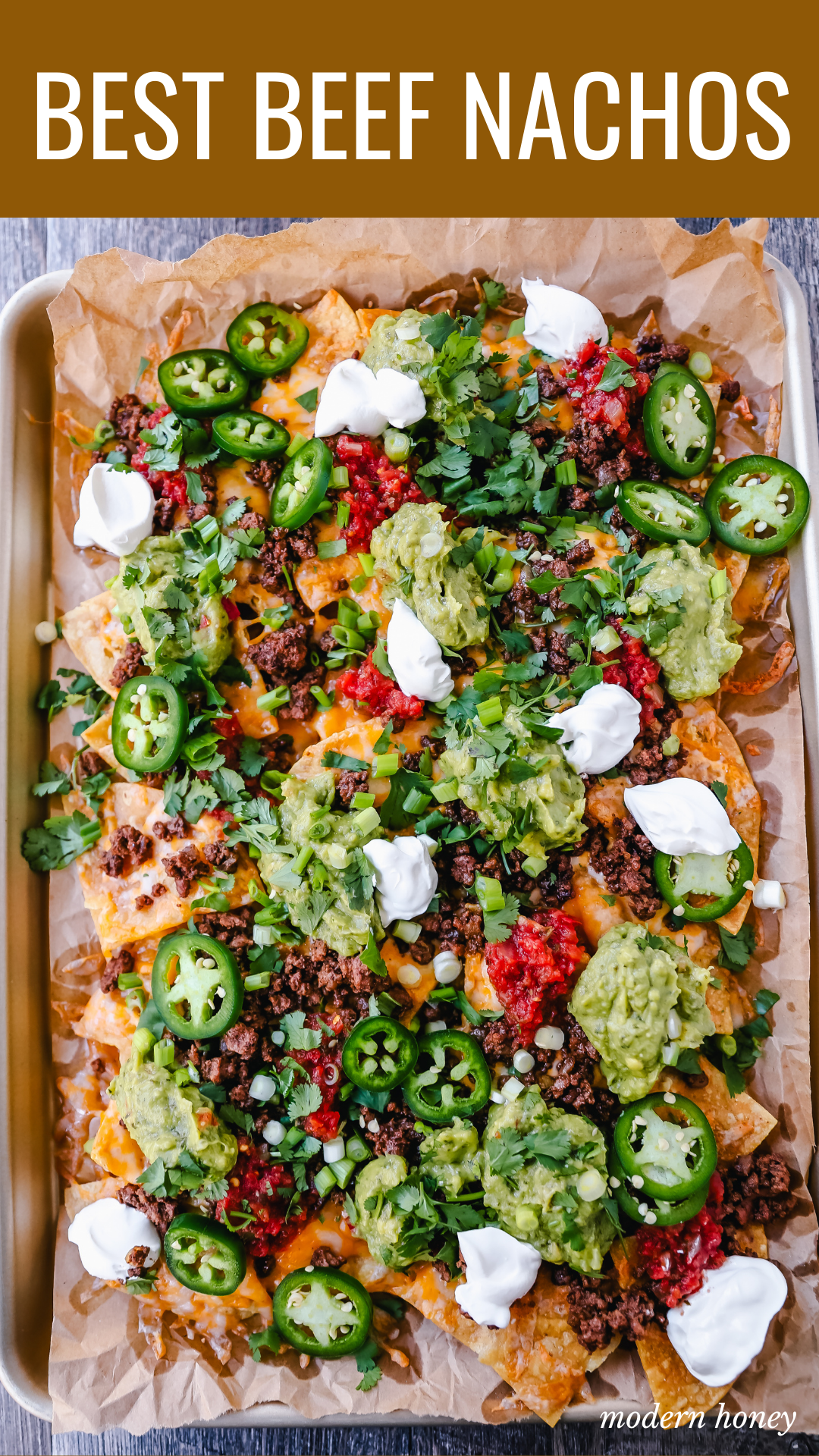 Ground Beef Nachos Recipe  Seasoned ground beef with crispy tortilla chips, Mexican cheeses, fresh guacamole, sour cream, jalapenos, fresh salsa, green onions, and cilantro make the best beef nachos!