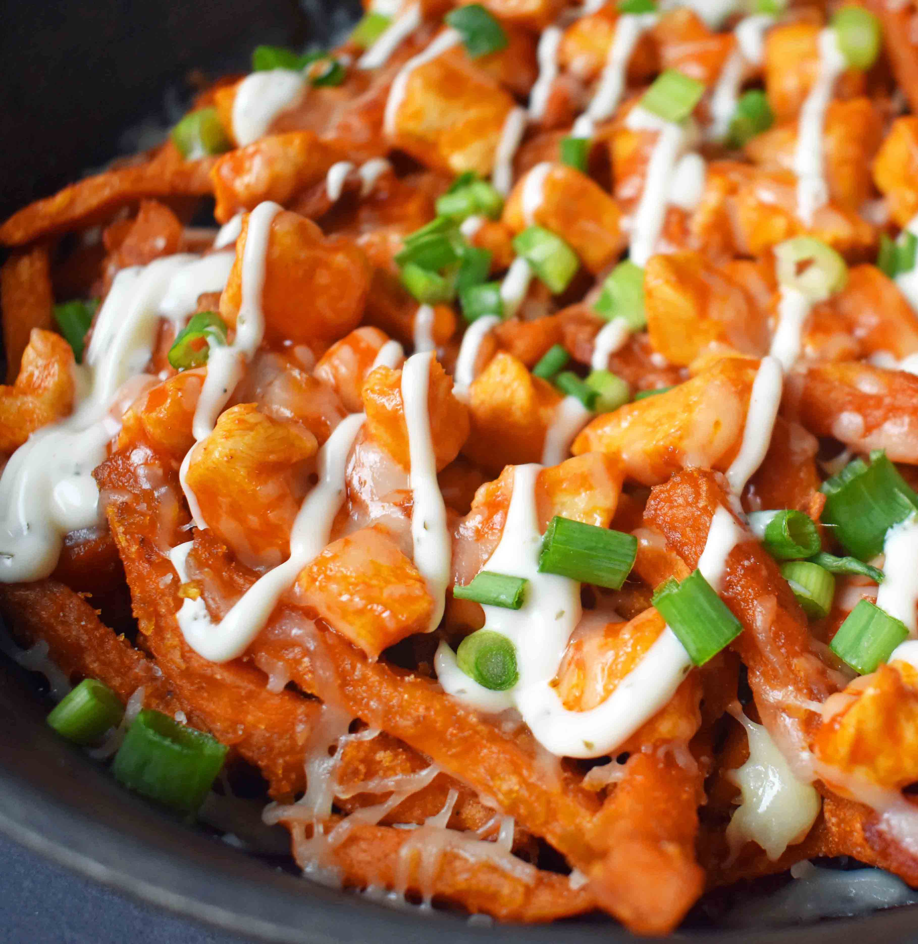 Buffalo Chicken Sweet Potato Fries by Modern Honey. Crisp Sweet Potato Fries topped with Buffalo Wing Chicken, Cheese, Green Onions, and Ranch Dressing. 