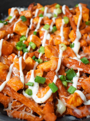 Buffalo Chicken Sweet Potato Fries by Modern Honey. Crisp Sweet Potato Fries topped with Buffalo Wing Chicken, Cheese, Green Onions, and Ranch Dressing.