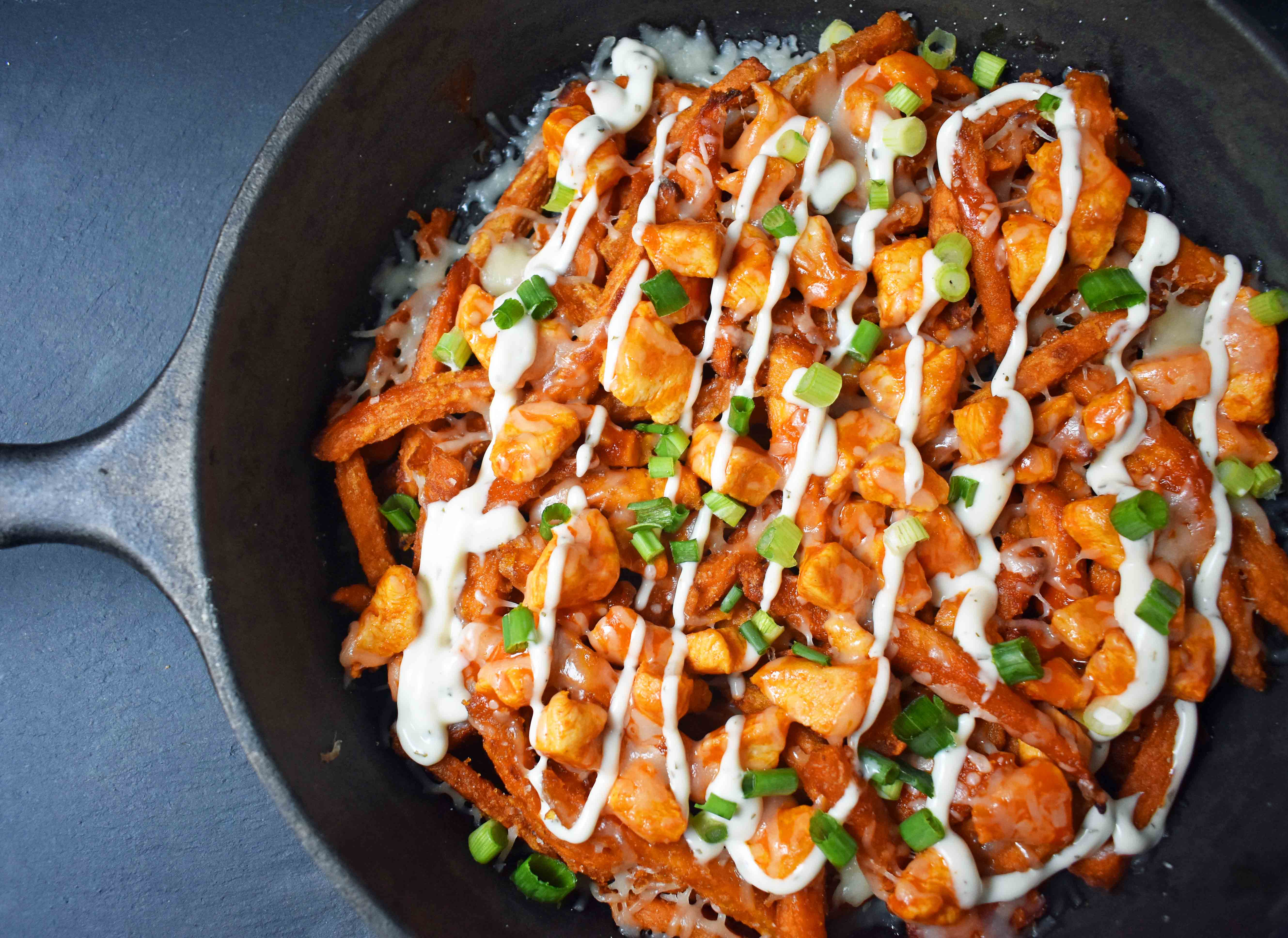 Buffalo Chicken Sweet Potato Fries by Modern Honey. Crisp Sweet Potato Fries topped with Buffalo Wing Chicken, Cheese, Green Onions, and Ranch Dressing. 