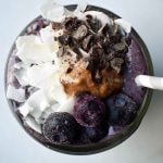 Wild Blueberry Chocolate Coconut Smoothie. Made with chocolate protein powder, coconut milk, blueberries, almond butter, banana, cacao powder. Topped with blueberries, almond butter, and dark chocolate shavings. A craveworthy chocolate coconut protein shake packed with nutrition. www.modernhoney.com