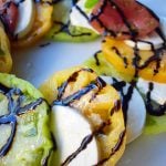 Heirloom Tomato Caprese Salad by Modern Honey. Garden Heirloom tomatoes layered with fresh mozzarella slices, extra virgin olive oil, balsamic glaze, salt, and fresh basil. A beautiful and healthy appetizer. www.modernhoney.com