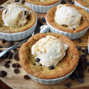 Mini Individual Chocolate Chip Cookie Sundae (Pizookie). The best chocolate chip cookie dough with a few secret techniques. The individual pizookies are baked in a ramekin until the edges are golden brown and the center is warm and gooey. The warm chocolate chip cookie is topped with ice cream. It's the most heavenly dessert! www.modernhoney.com