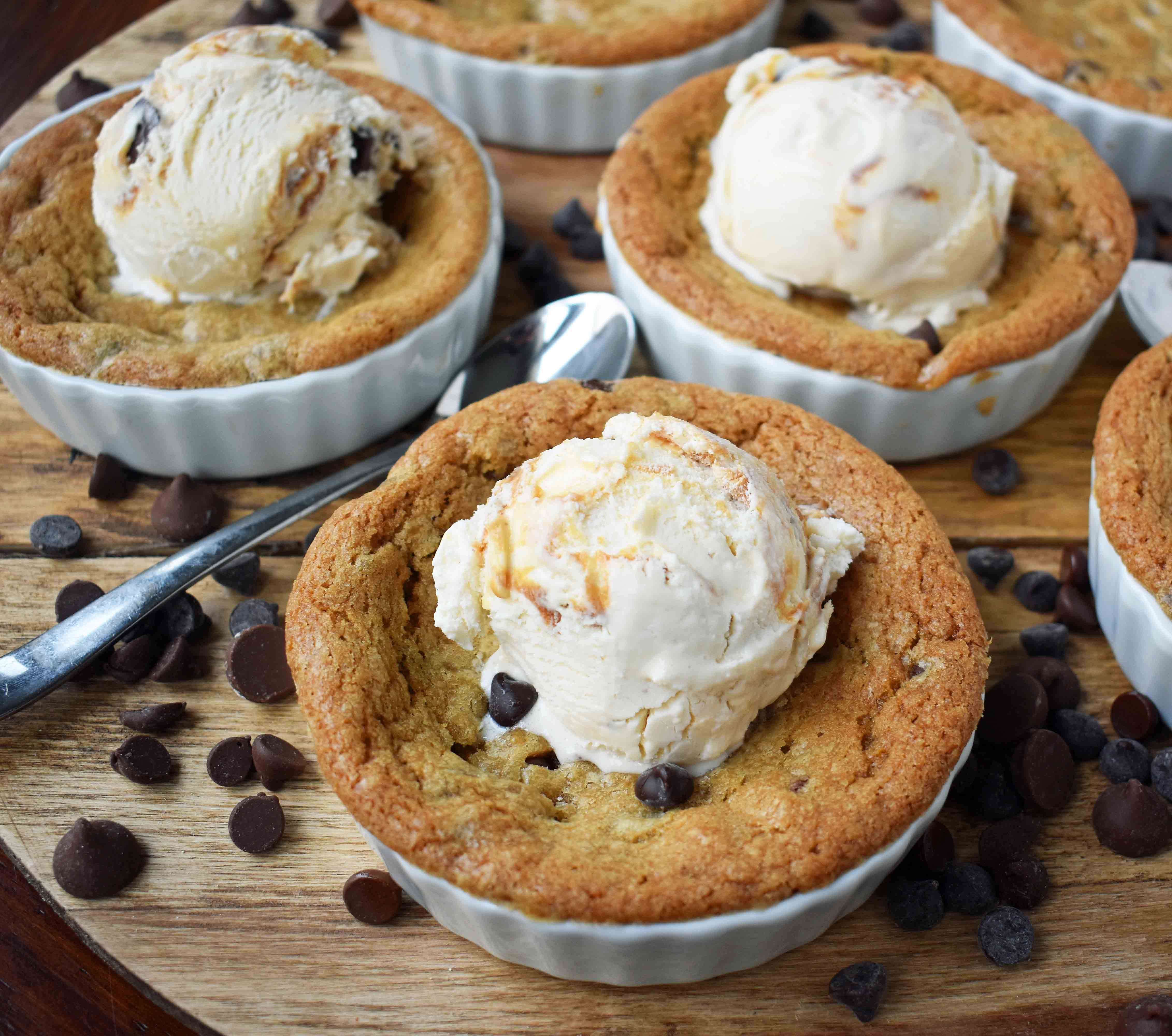 Mini Individual Chocolate Chip Cookie Sundae (Pizookie). The best chocolate chip cookie dough with a few secret techniques. The individual pizookies are baked in a ramekin until the edges are golden brown and the center is warm and gooey. The warm chocolate chip cookie is topped with ice cream. It's the most heavenly dessert! www.modernhoney.com