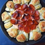 Pepperoni Pizza Dip with Pizza Crust Dippers by Modern Honey. Creamy pizza dip topped with crispy pepperoni and baked with garlic butter pizza rolls. All baked in a cast iron skillet. www.modernhoney.com