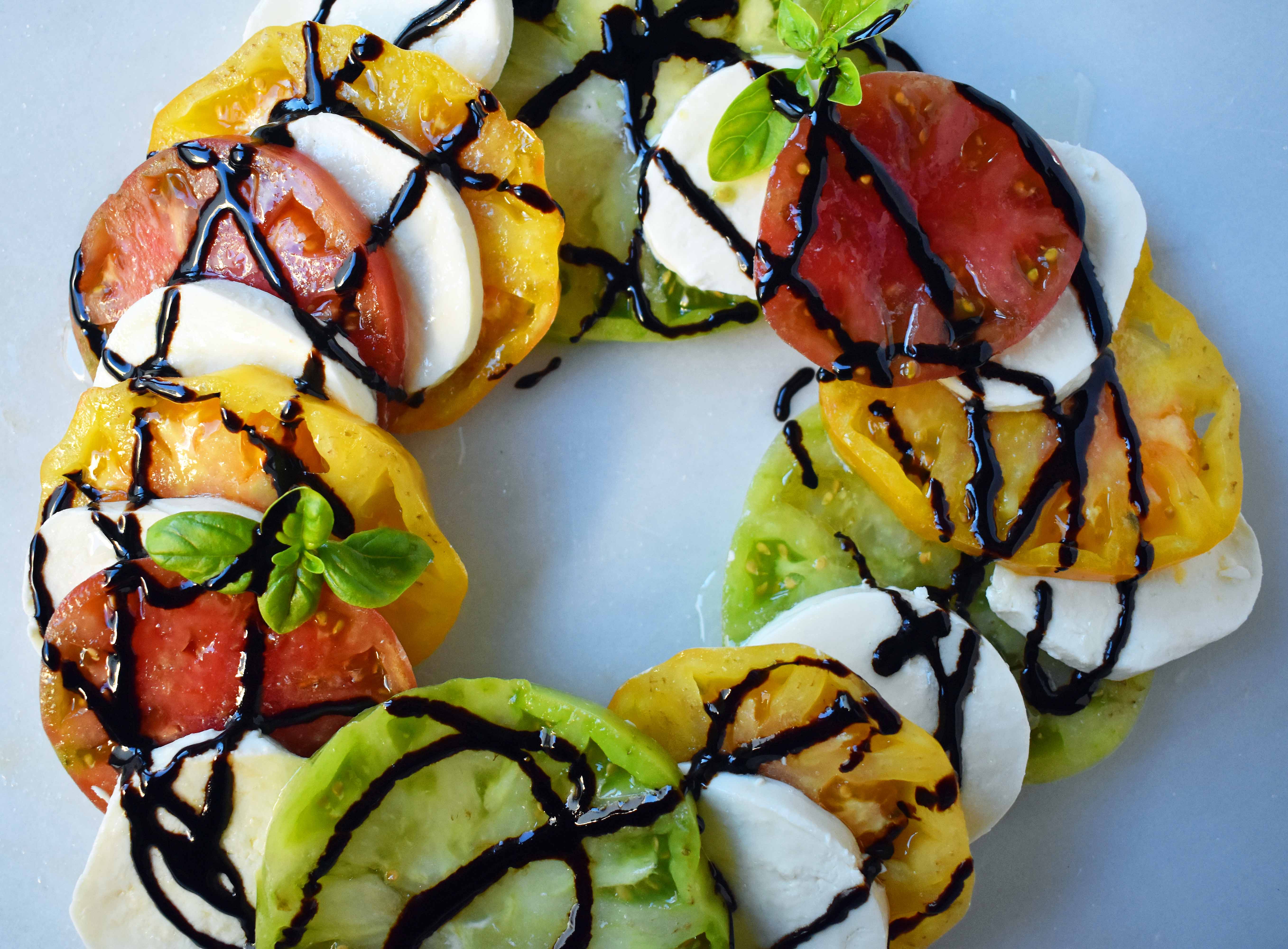 Heirloom Tomato Caprese Salad by Modern Honey. Garden Heirloom tomatoes layered with fresh mozzarella slices, extra virgin olive oil, balsamic glaze, salt, and fresh basil. A beautiful and healthy appetizer. www.modernhoney.com