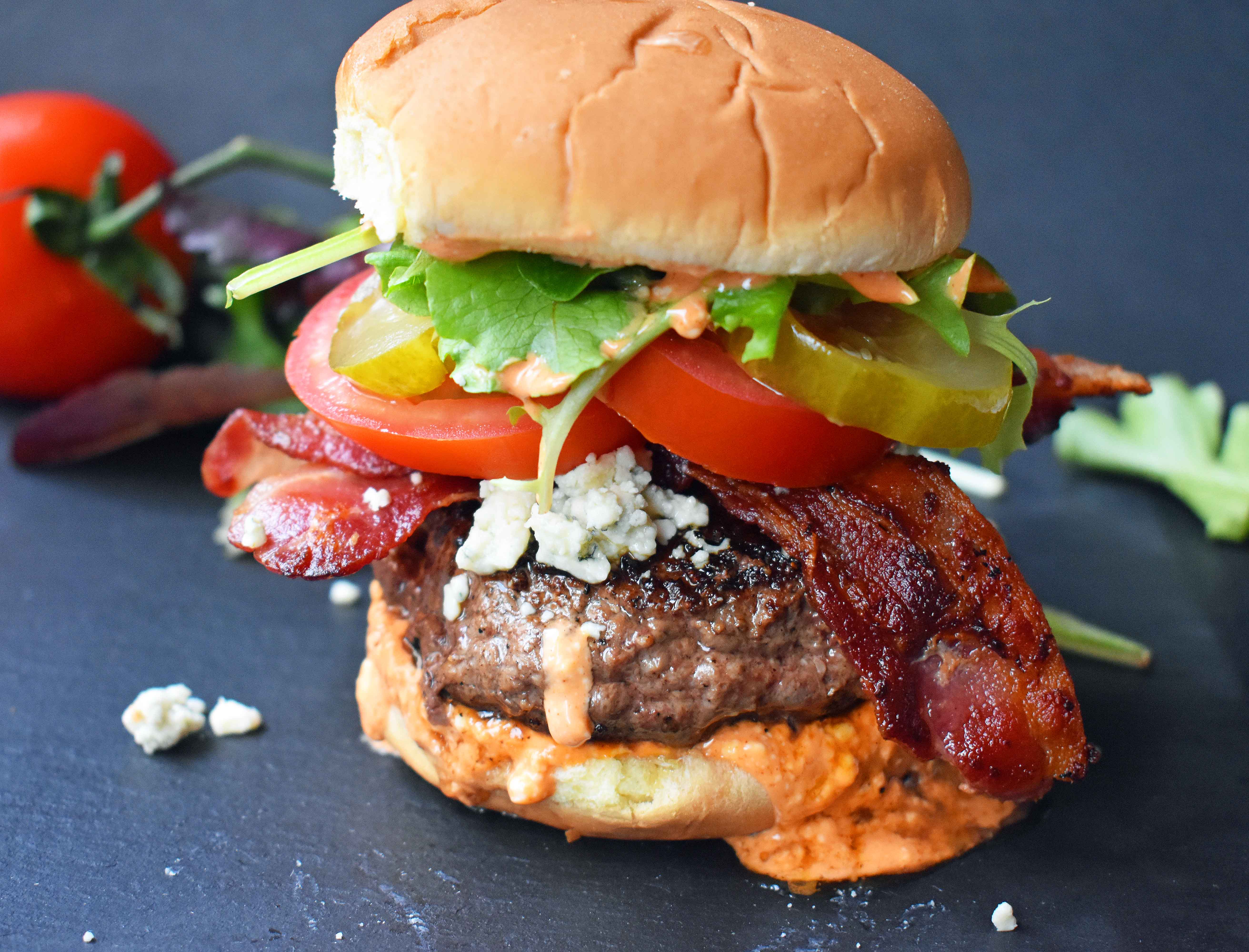 Dragonslayer Burger. Beef with blue cheese, crispy bacon, juicy tomatoes, crunchy pickles, spring mix, and buffalo ranch sauce. www.modernhoney.com