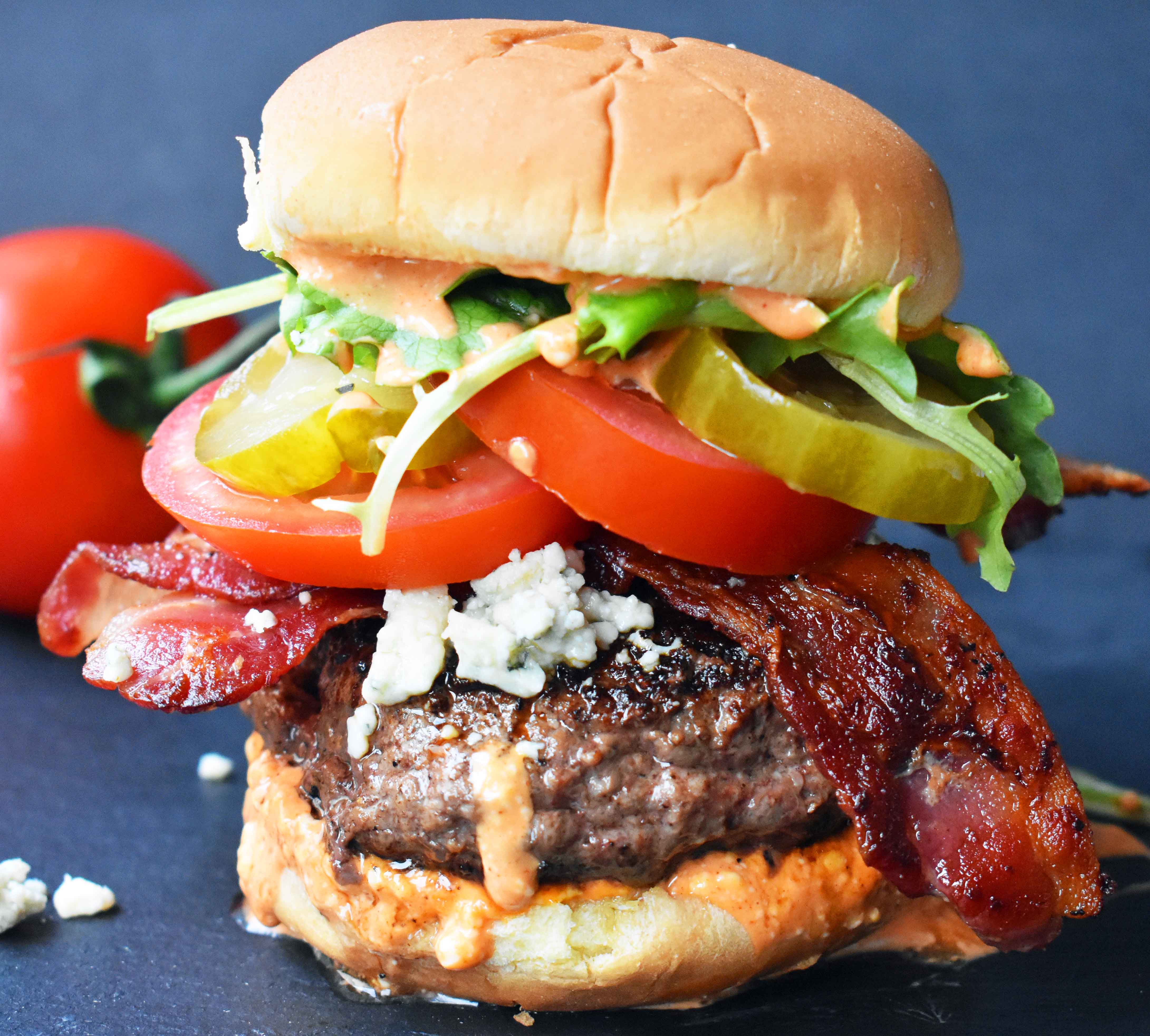 Dragonslayer Burger. Beef with blue cheese, crispy bacon, juicy tomatoes, crunchy pickles, spring mix, and buffalo ranch sauce. www.modernhoney.com
