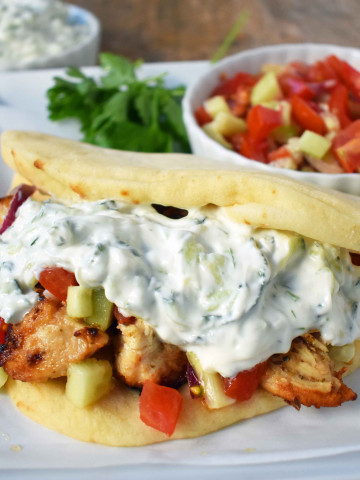 Greek Chicken Gyros with Tzatziki Sauce. Marinated Greek Chicken, grilled to perfection and topped with homemade tzatziki sauce and fresh Greek salad. A healthy and flavorful dish. www.modernhoney.com