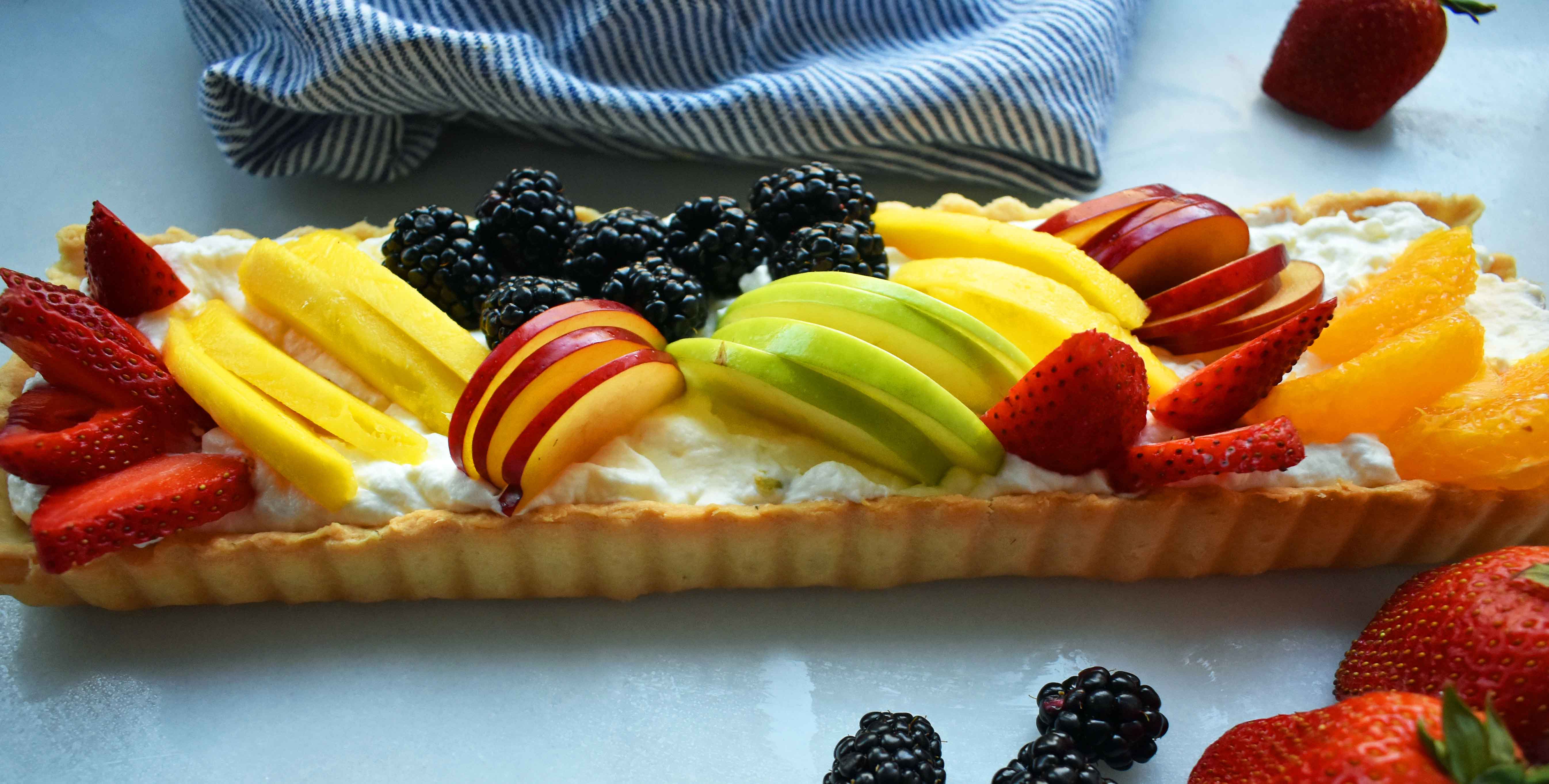 Lemon Cream Filled Fruit Tart. Buttery, flaky pie crust baked in tart pan and filled with homemade lemon cream and topped with sliced fresh fruit. A beautiful Spring and Summer dessert that everyone loves. www.modernhoney.com