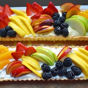 Lemon Cream Filled Fruit Tart. Buttery, flaky pie crust baked in tart pan and filled with homemade lemon cream and topped with sliced fresh fruit. A beautiful Spring and Summer dessert that everyone loves. www.modernhoney.com