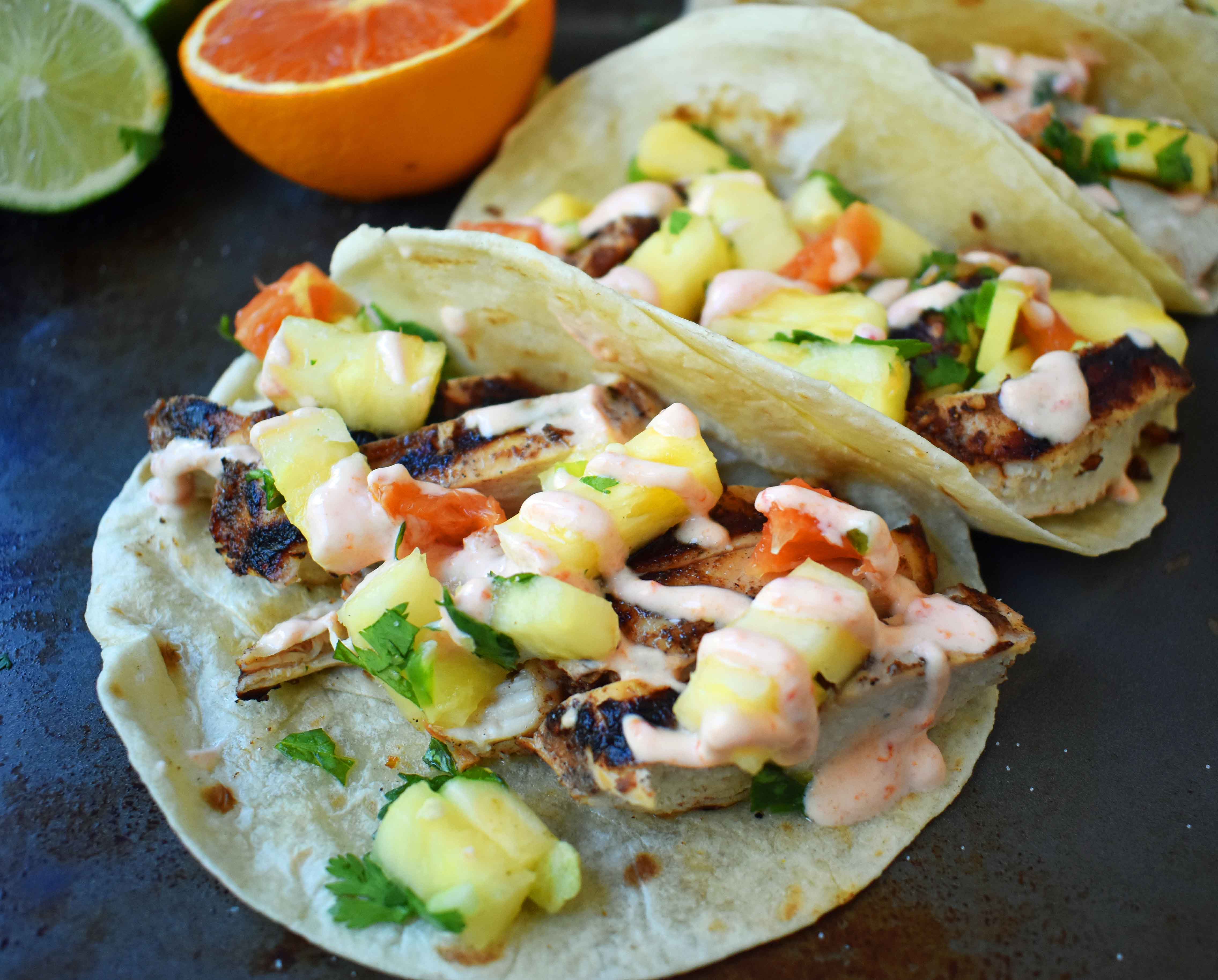 Jamaican Jerk Chicken Tacos. Caribbean spiced citrus grilled chicken filled tacos with pineapple salsa and spicy cream. www.modernhoney.com