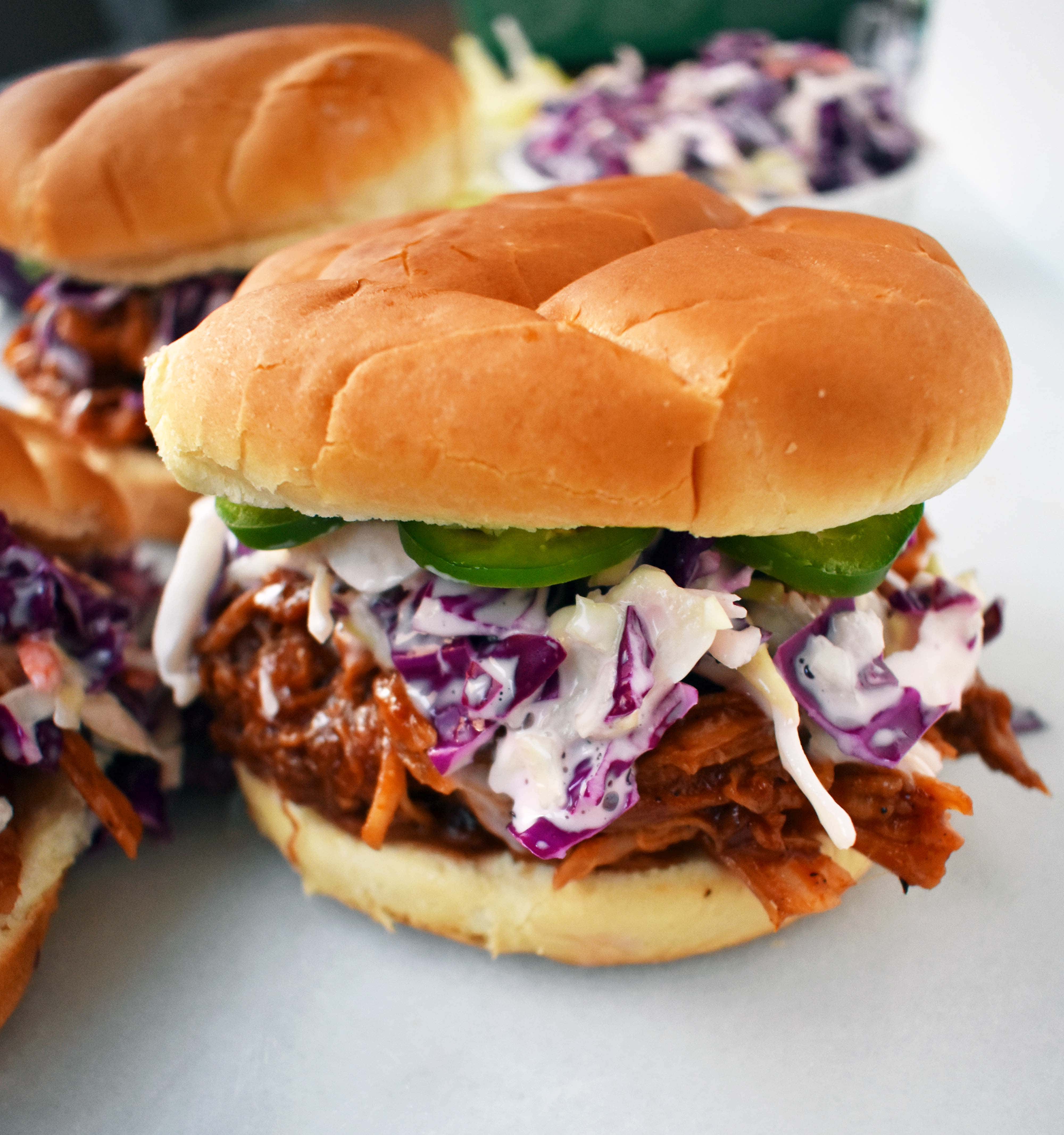 långsam spis Dr.Pepper drog fläsk smörgås. Långsam kokt fläsk sjuda med Dr. peppar, kryddor, och BBQ sås. Toppad med hemlagad coleslaw och färska jalapenos, allt på en mjuk bulle. Den perfekta BBQ drog fläsk smörgås. www.modernhoney.com