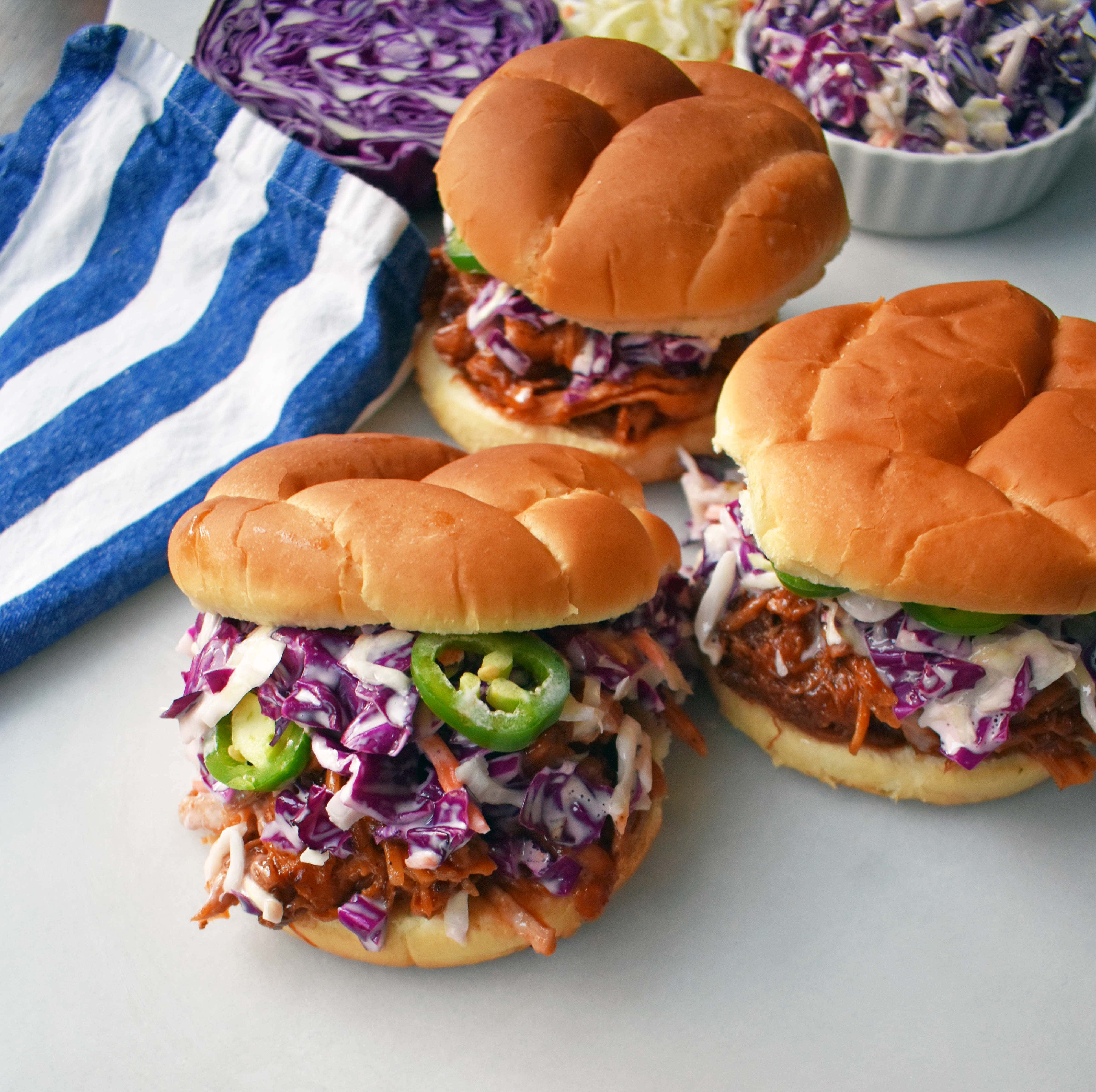 Sakte Komfyr Dr. Pepper Trakk Svinekjøtt Sandwich. Kongereker tilberedt med Spinat, hvitløk, urter og KRYDDER. Toppet med hjemmelaget coleslaw og friske jalapenos, alt pa en myk bun. Den perfekte BBQ Pulled Pork Sandwich. www.modernhoney.com