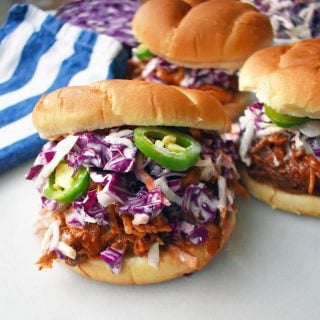Slow Cooker Dr. Pepper Pulled Pork Sandwich. Slow cooked pork simmered with Dr. Pepper, spices, and BBQ sauce. Topped with homemade coleslaw and fresh jalapenos, all on a soft bun. The perfect BBQ Pulled Pork Sandwich. www.modernhoney.com
