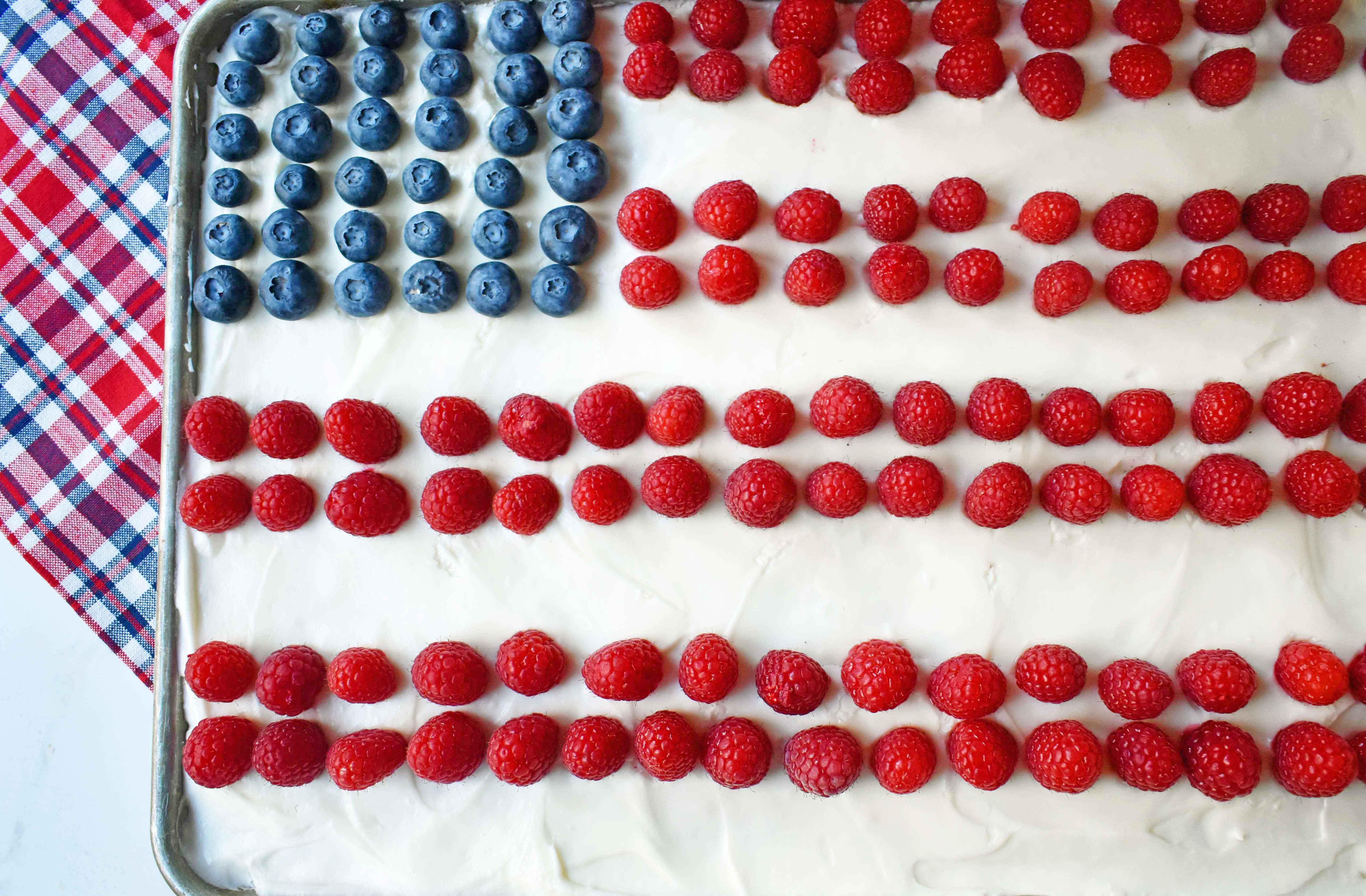 Vanilla Almond White Texas Sheet Cake. A vanilla white cake poured to a jelly roll pan and baked until moist and tender. Topped with almond cream cheese frosting and fresh berries. Perfect flag cake for a 4th of July celebration. www.modernhoney.com